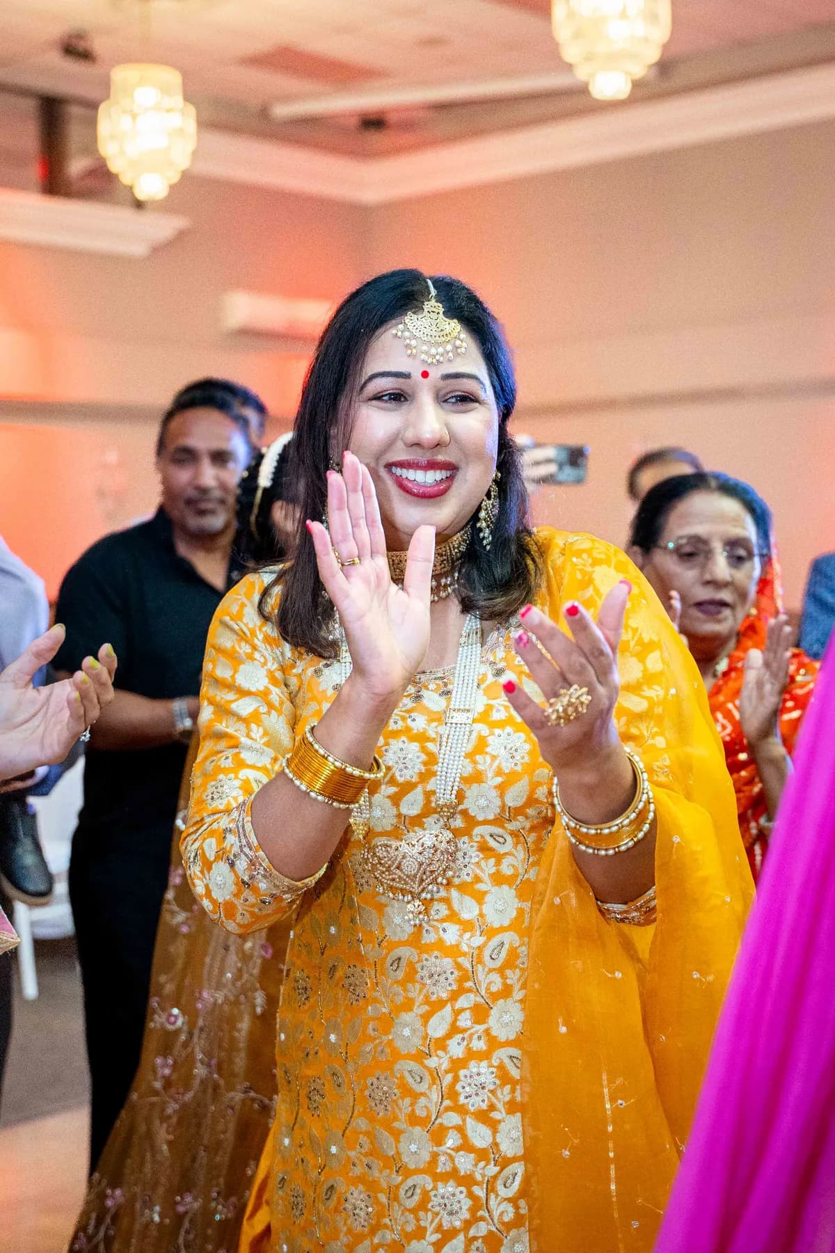 Guests dancing with decorated vessels at Jessie and Erin’s Haldi celebration.