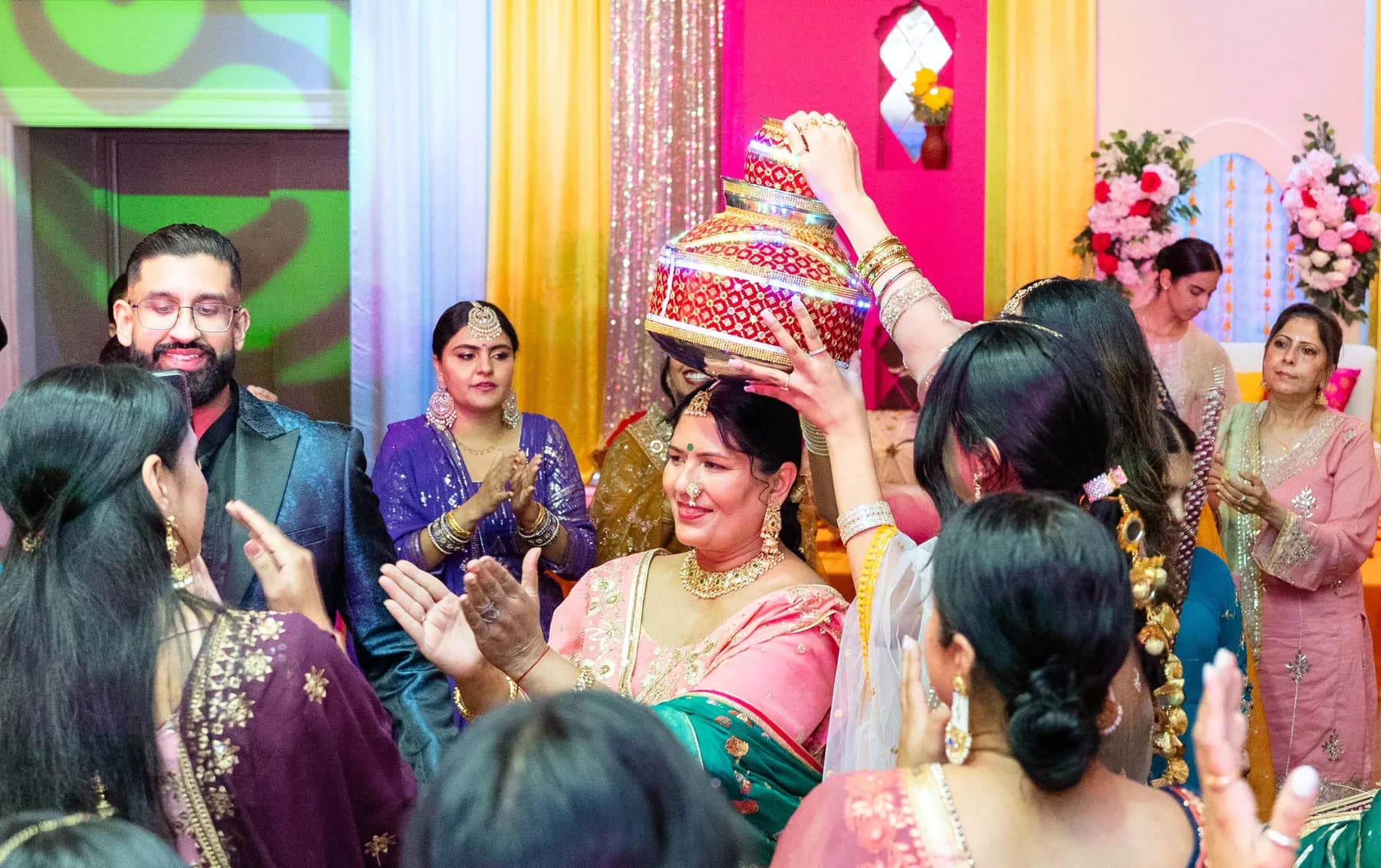 Guests dancing with decorated vessels at Jessie and Erin’s Haldi celebration.