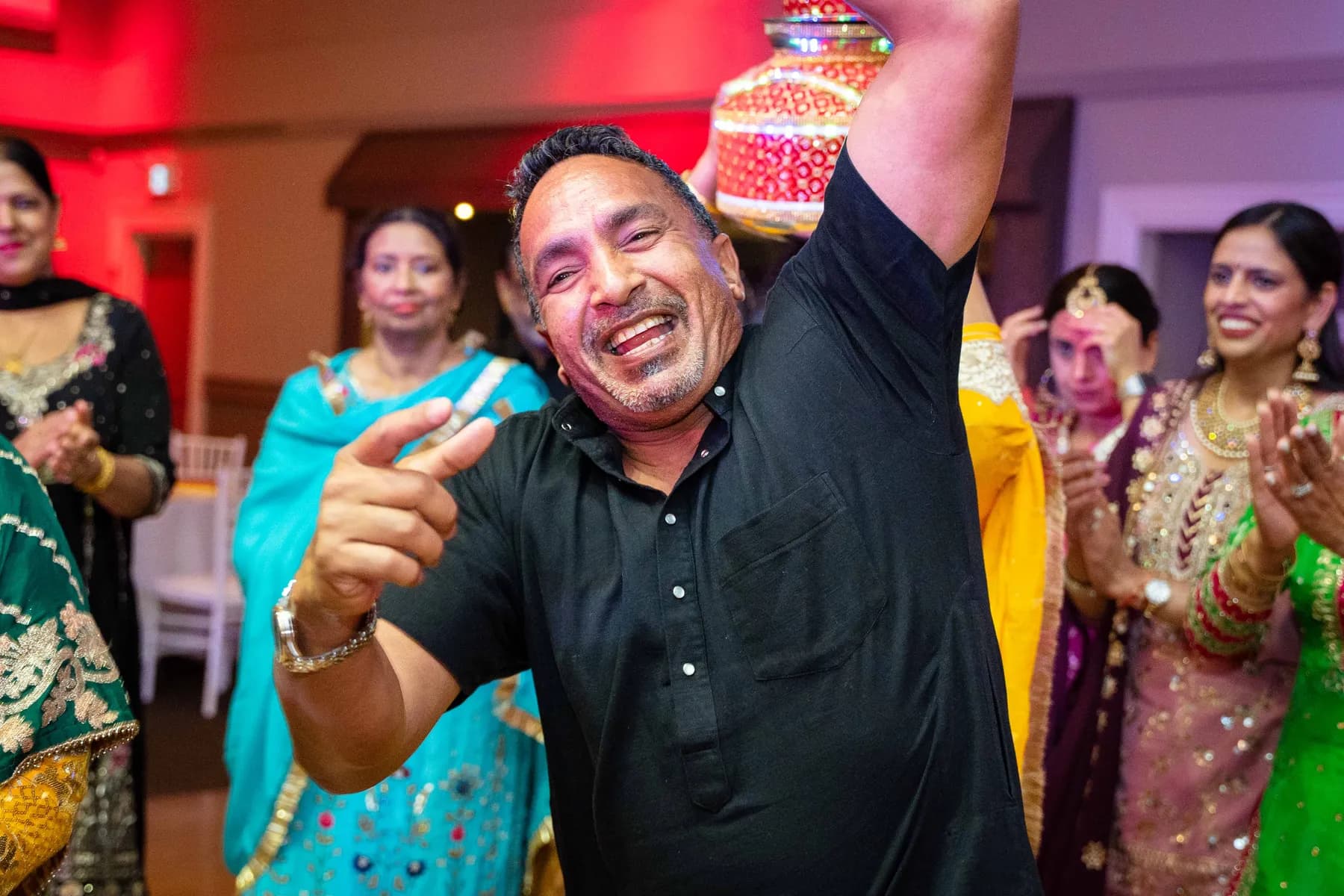 Guests dancing with decorated vessels at Jessie and Erin’s Haldi celebration.