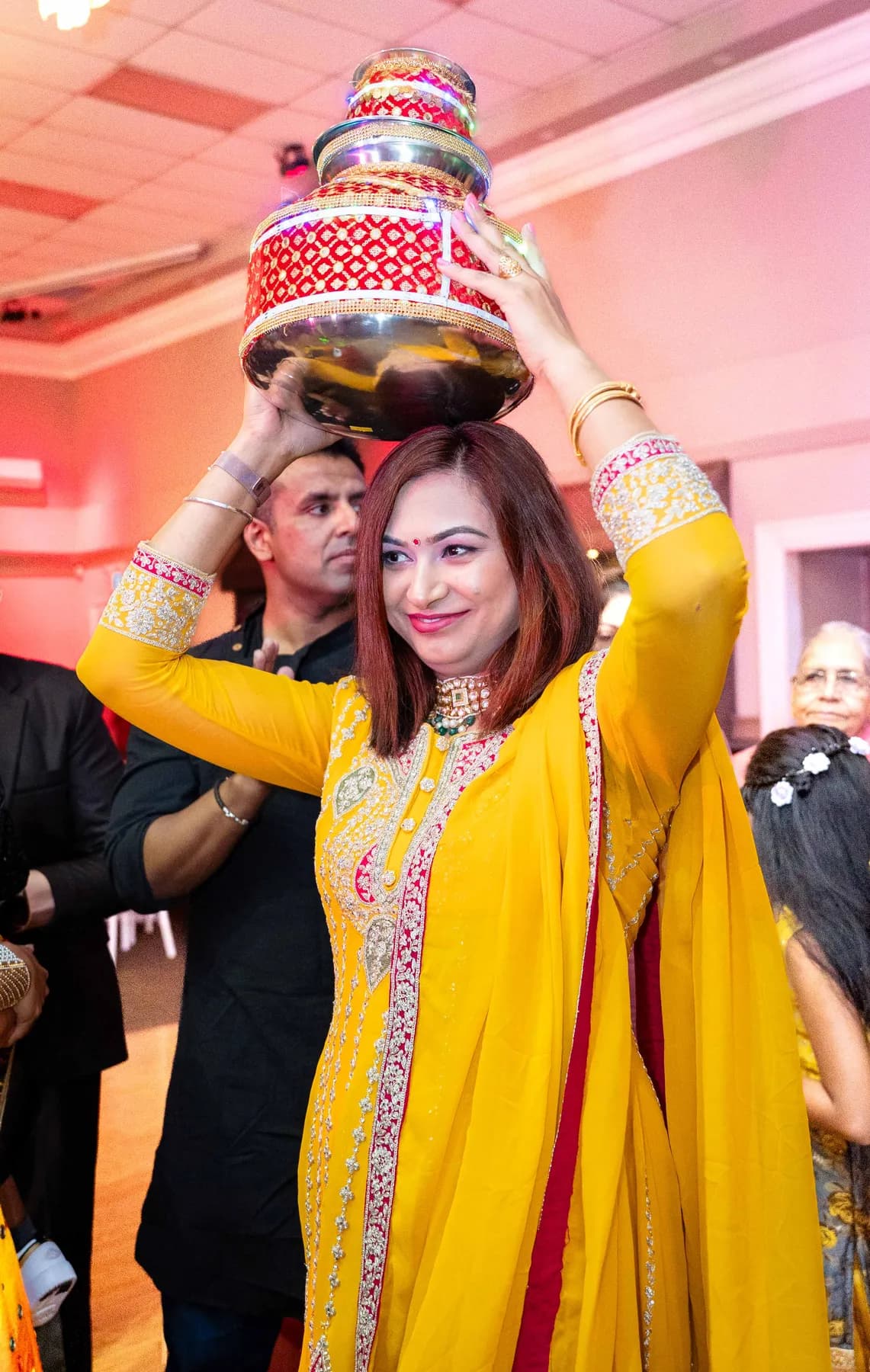 Guests dancing with decorated vessels at Jessie and Erin’s Haldi celebration.