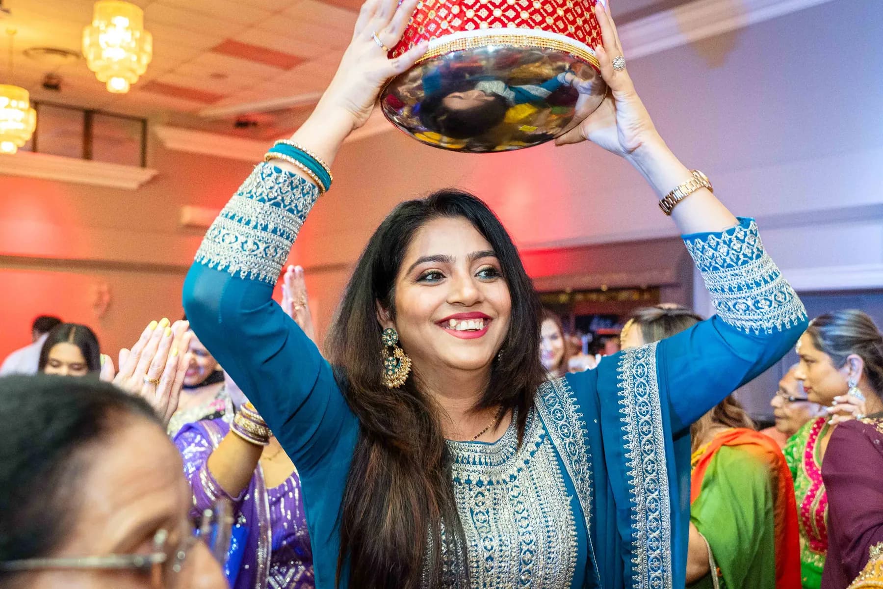Guests dancing with decorated vessels at Jessie and Erin’s Haldi celebration.