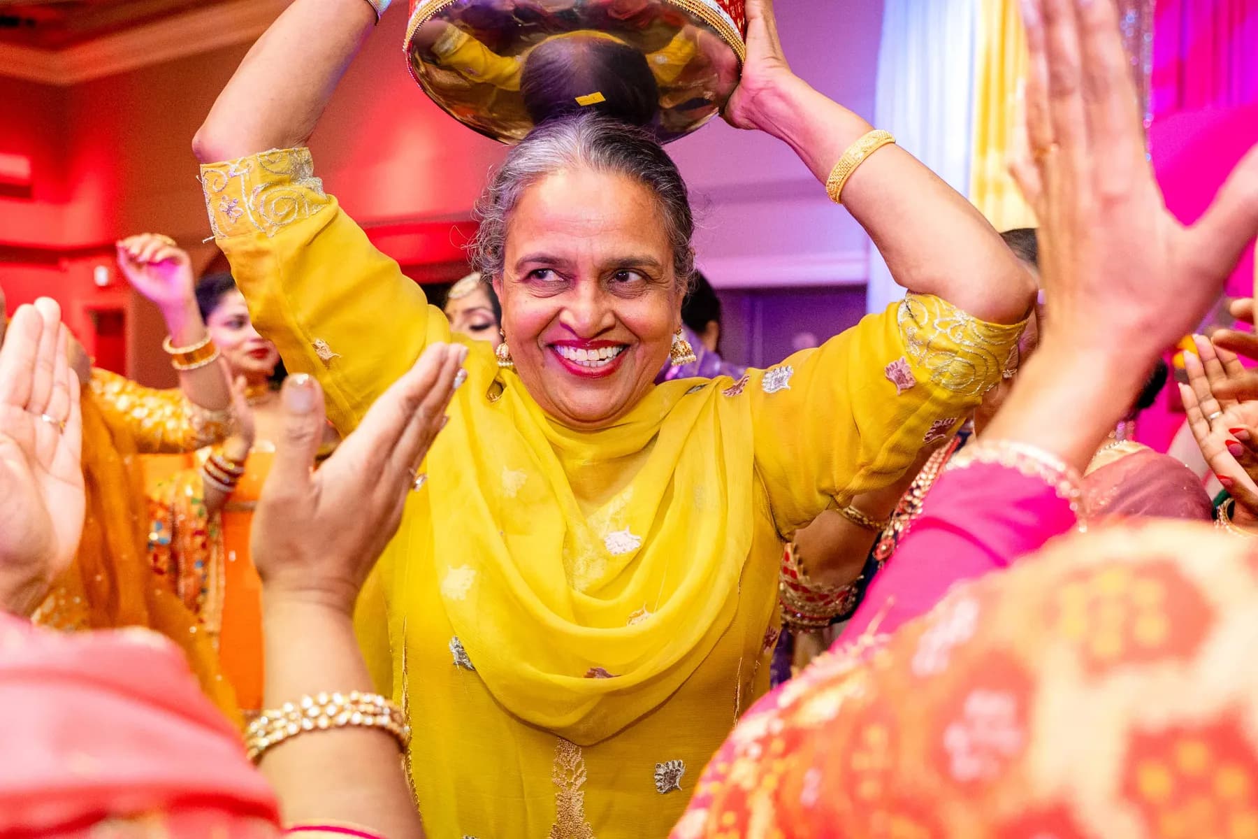 Guests dancing with decorated vessels at Jessie and Erin’s Haldi celebration.