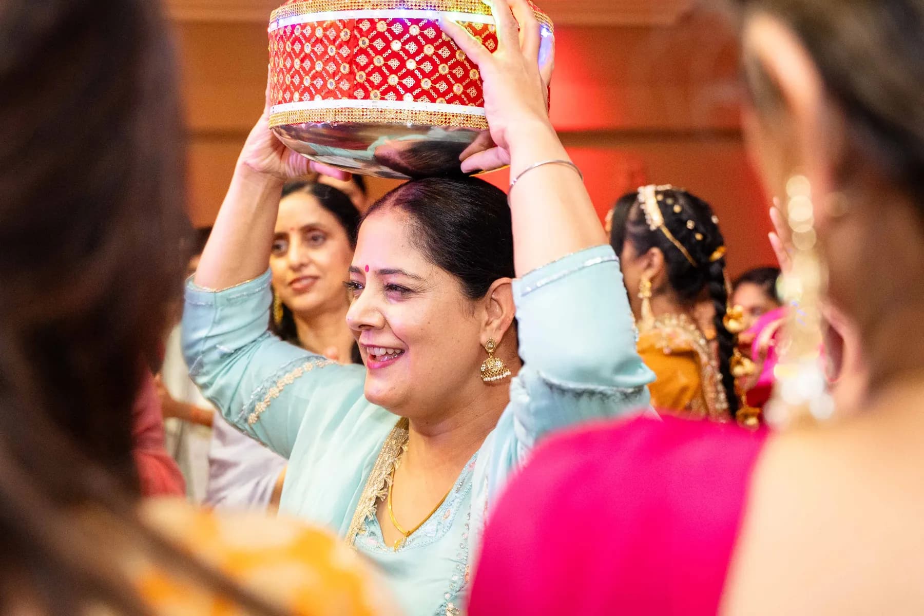 Guests dancing with decorated vessels at Jessie and Erin’s Haldi celebration.