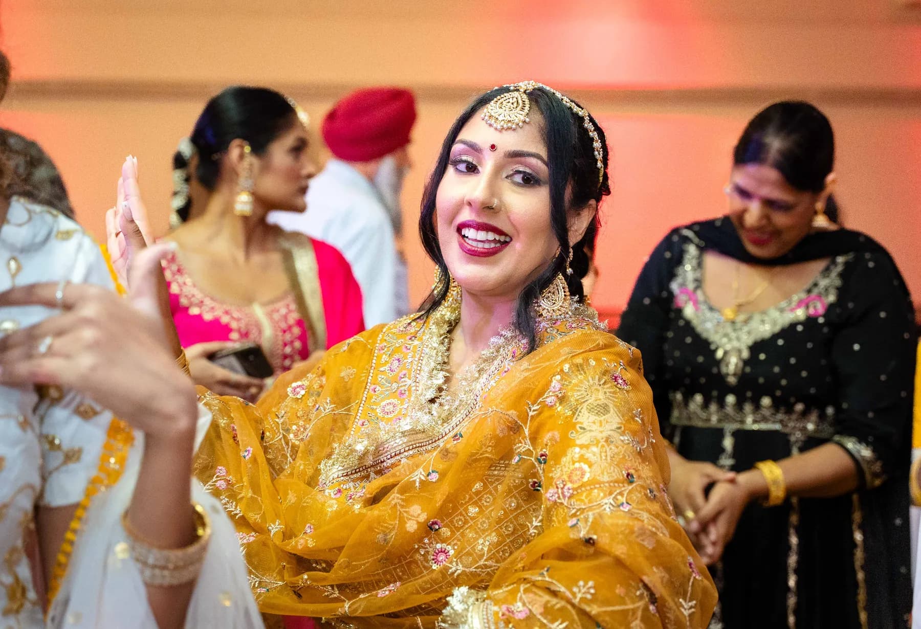 A woman dancing with the guests at Jessie and Erin’s Haldi celebration.