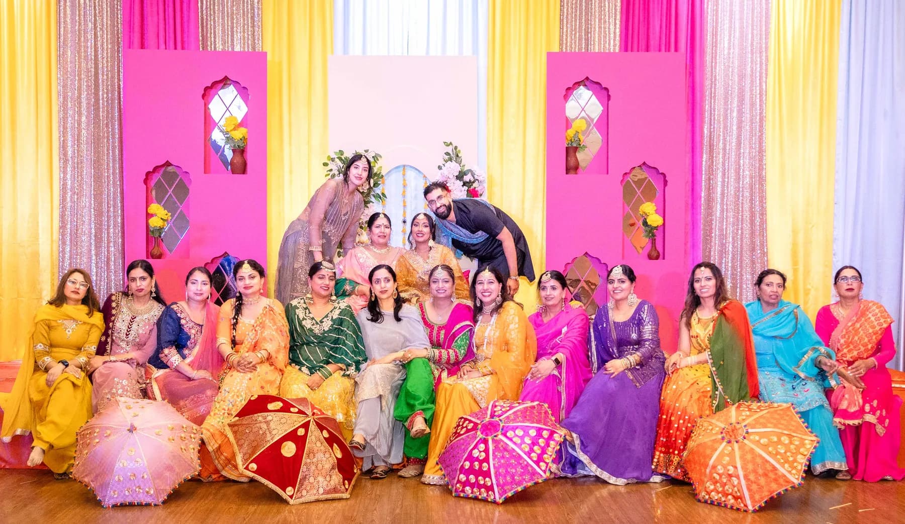 A large group posing on the stage at Jessie and Erin’s Haldi celebration.