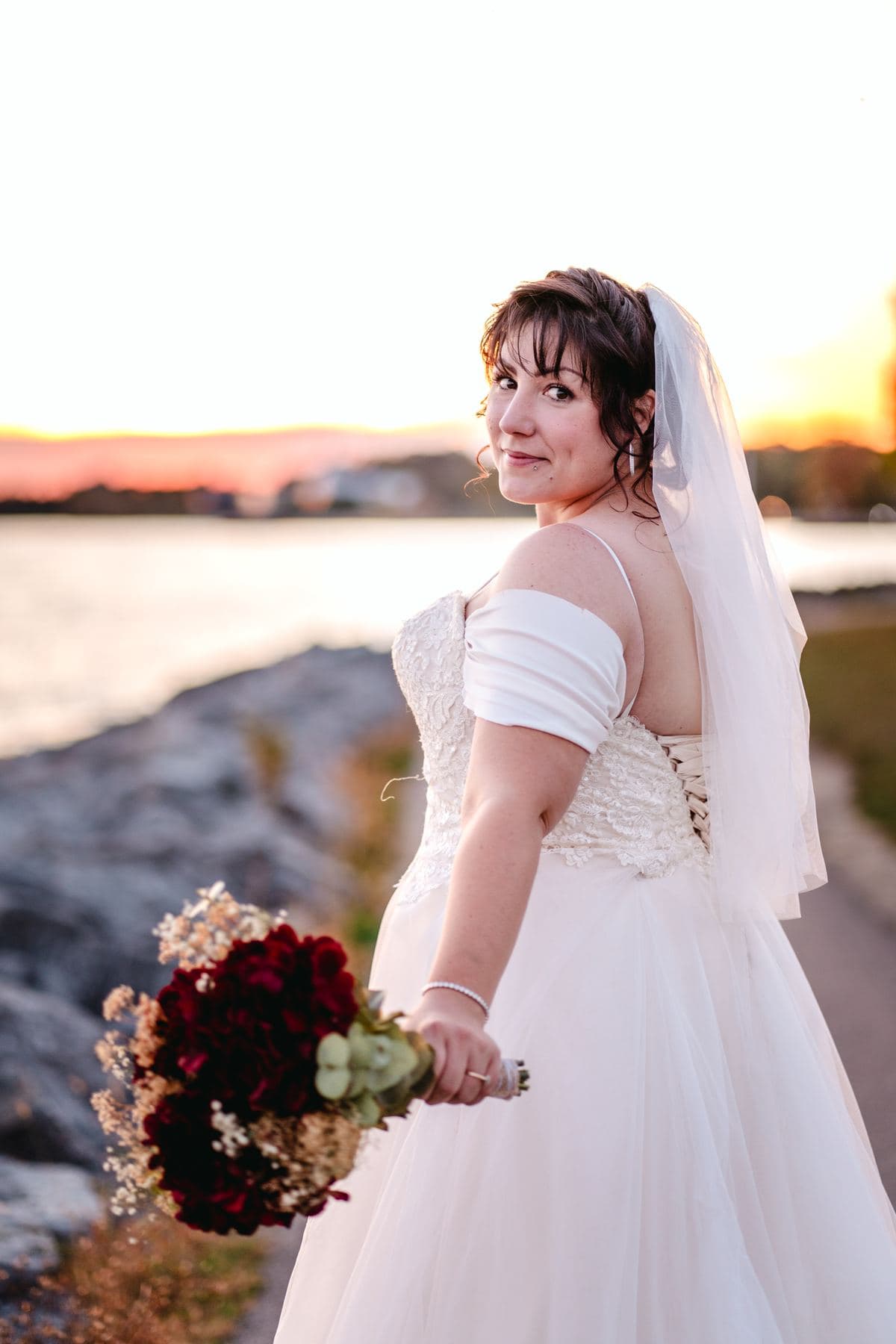 A bride standing beside the lake
