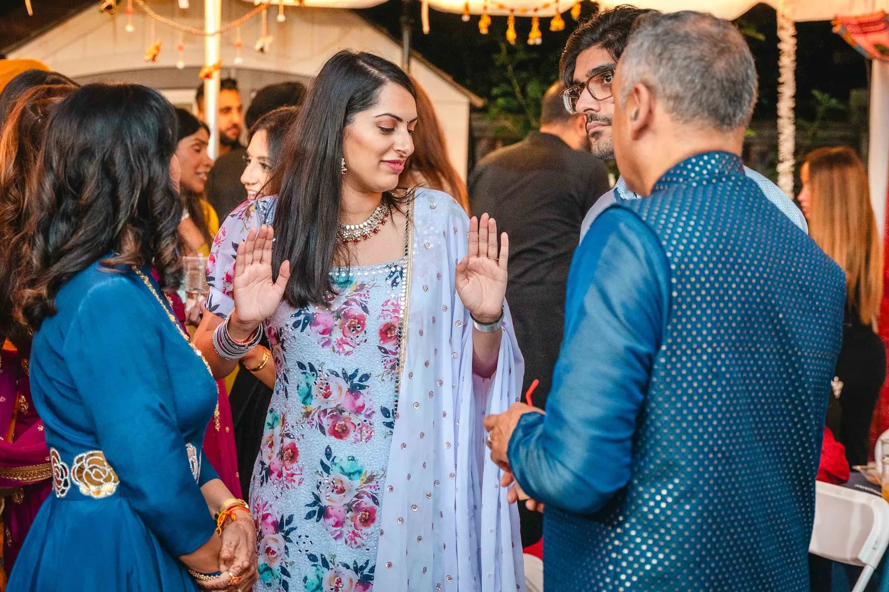 Guests celebrating under evening lights at Aaron’s Haldi celebration.