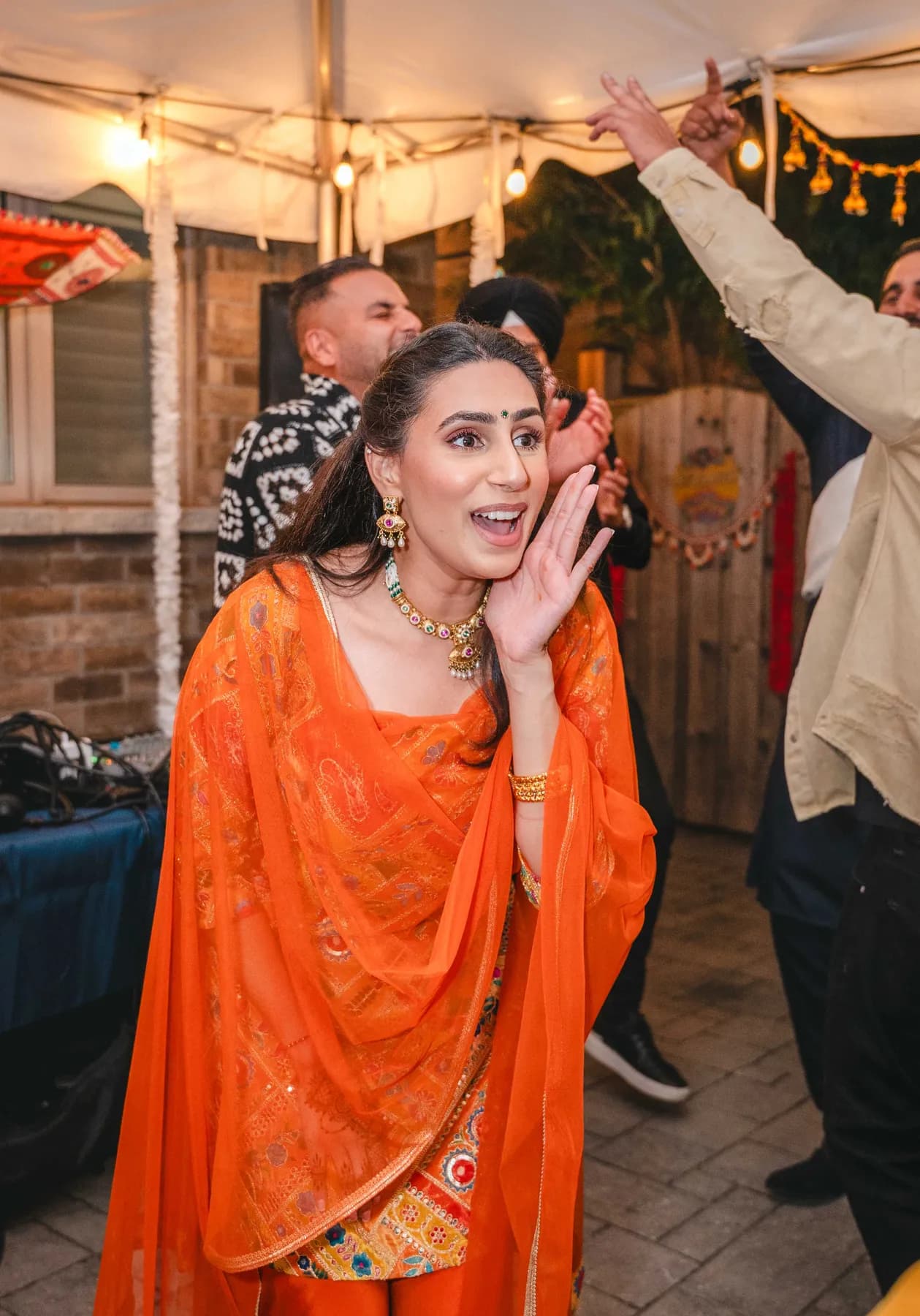 Guests dancing under evening lights at Aaron’s Haldi celebration.