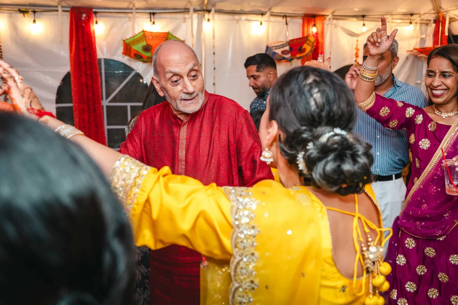 Guests dancing under evening lights at Aaron’s Haldi celebration.