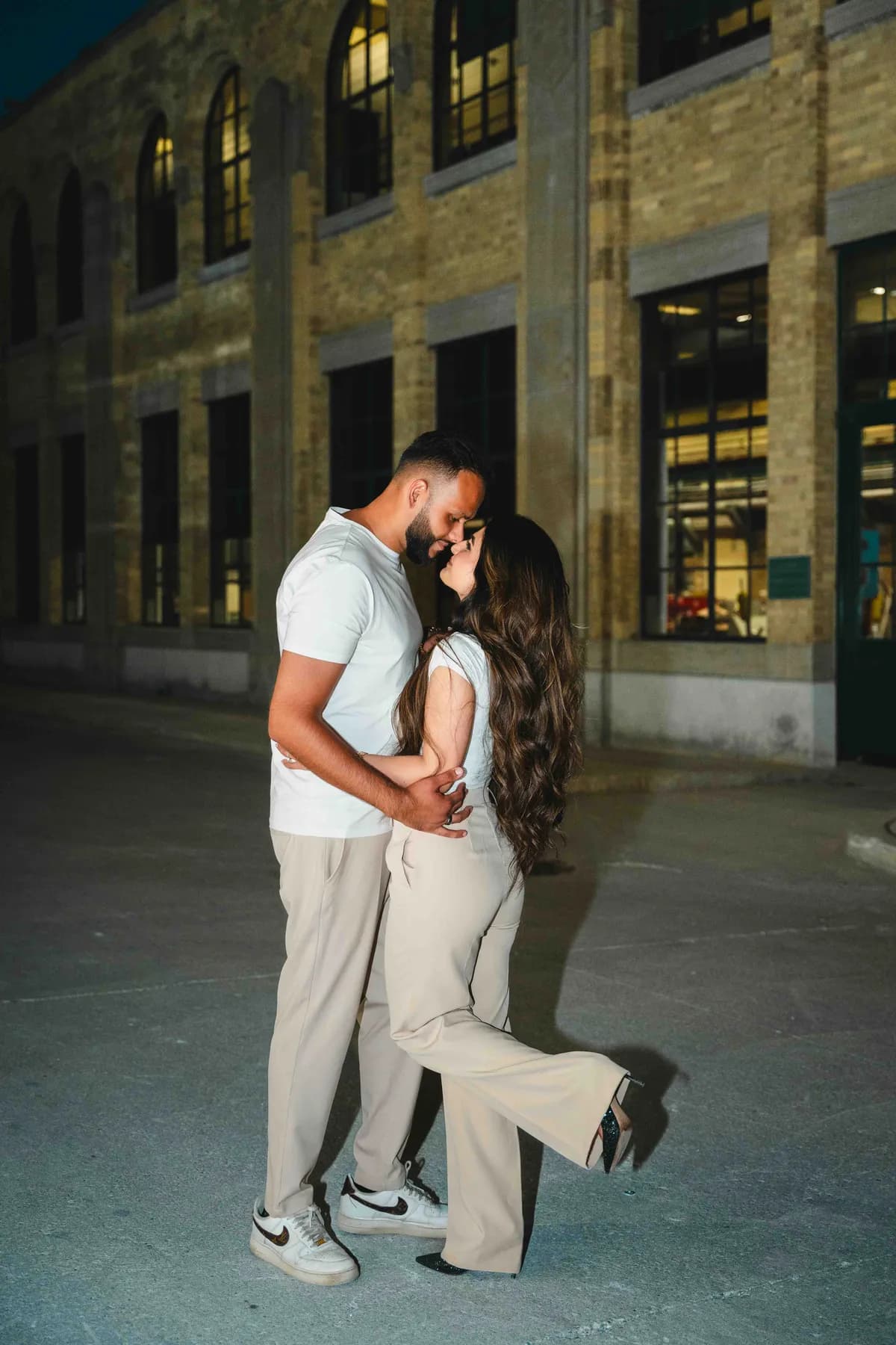 The couple kissing outside a city building at A and F’s couples session.