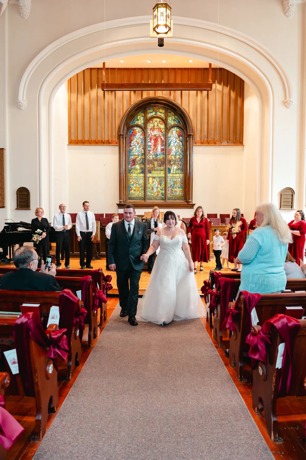 The couple walking down the church aisle after the ceremony at Kody and Jaz’s wedding.