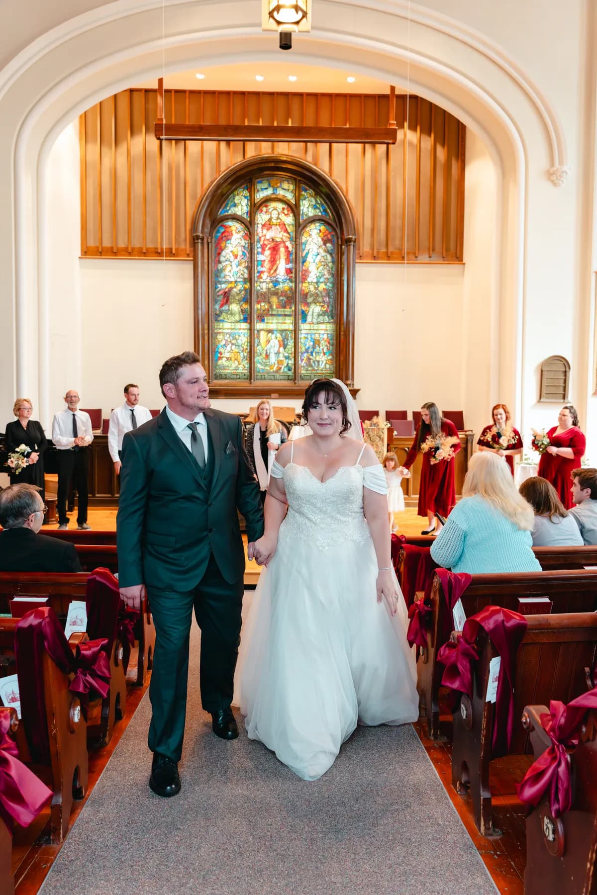 The couple walking down the church aisle after the ceremony at Kody and Jaz’s wedding.