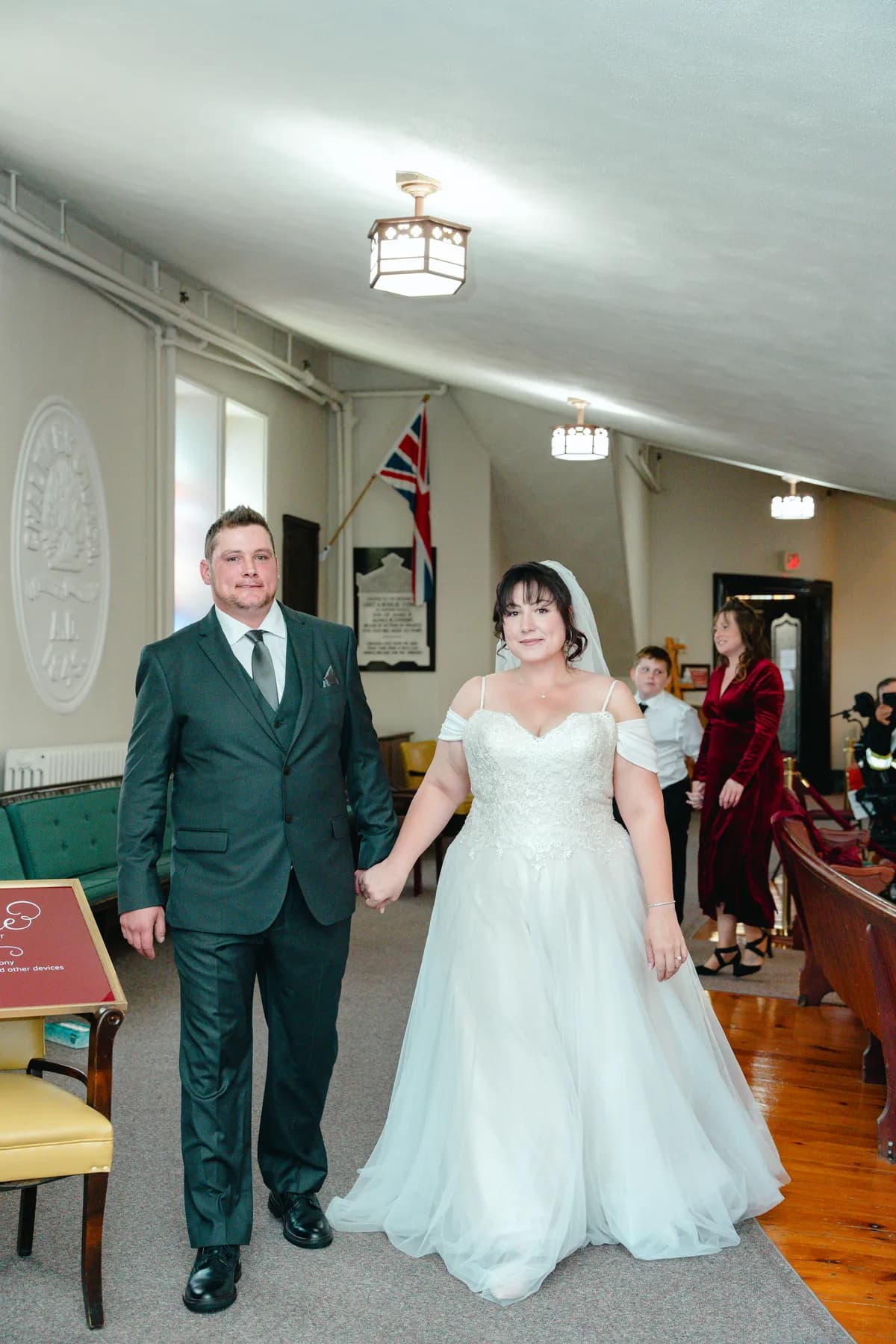 The couple walking indoors after the ceremony at Kody and Jaz’s wedding.