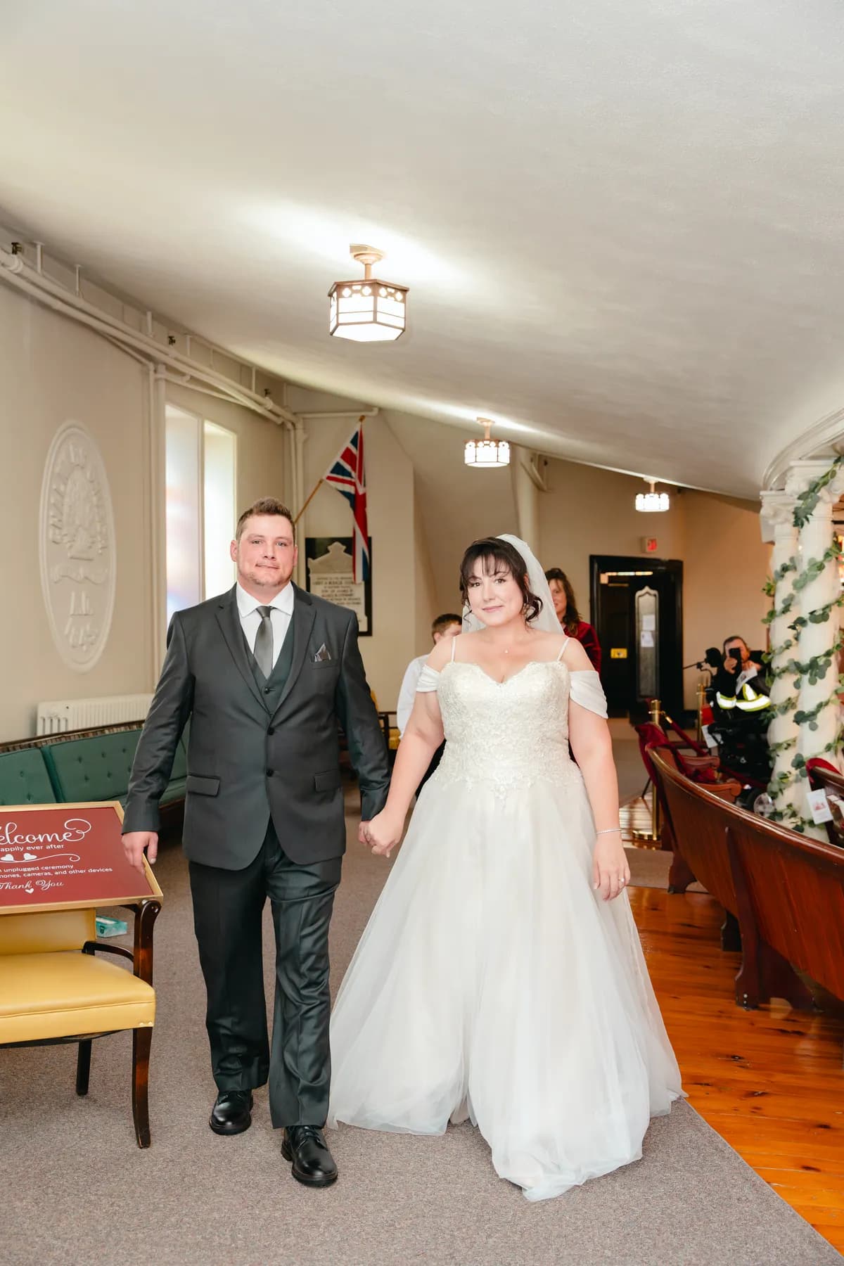 The couple walking indoors after the ceremony at Kody and Jaz’s wedding.