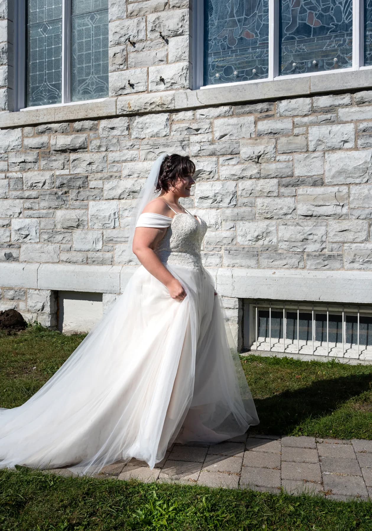 The bride posing with a male guest outside the church at Kody and Jaz’s wedding.