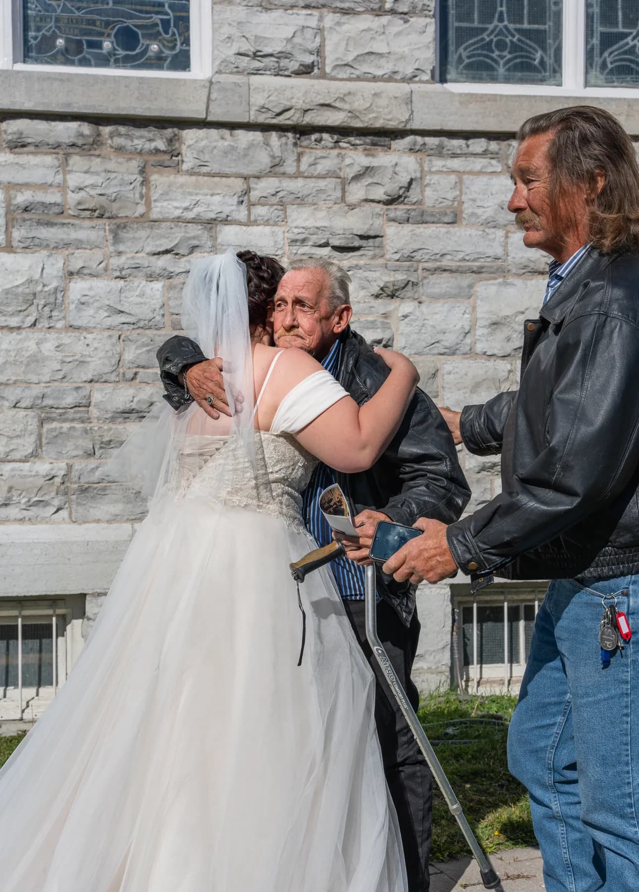 The bride posing with a male guest outside the church at Kody and Jaz’s wedding.