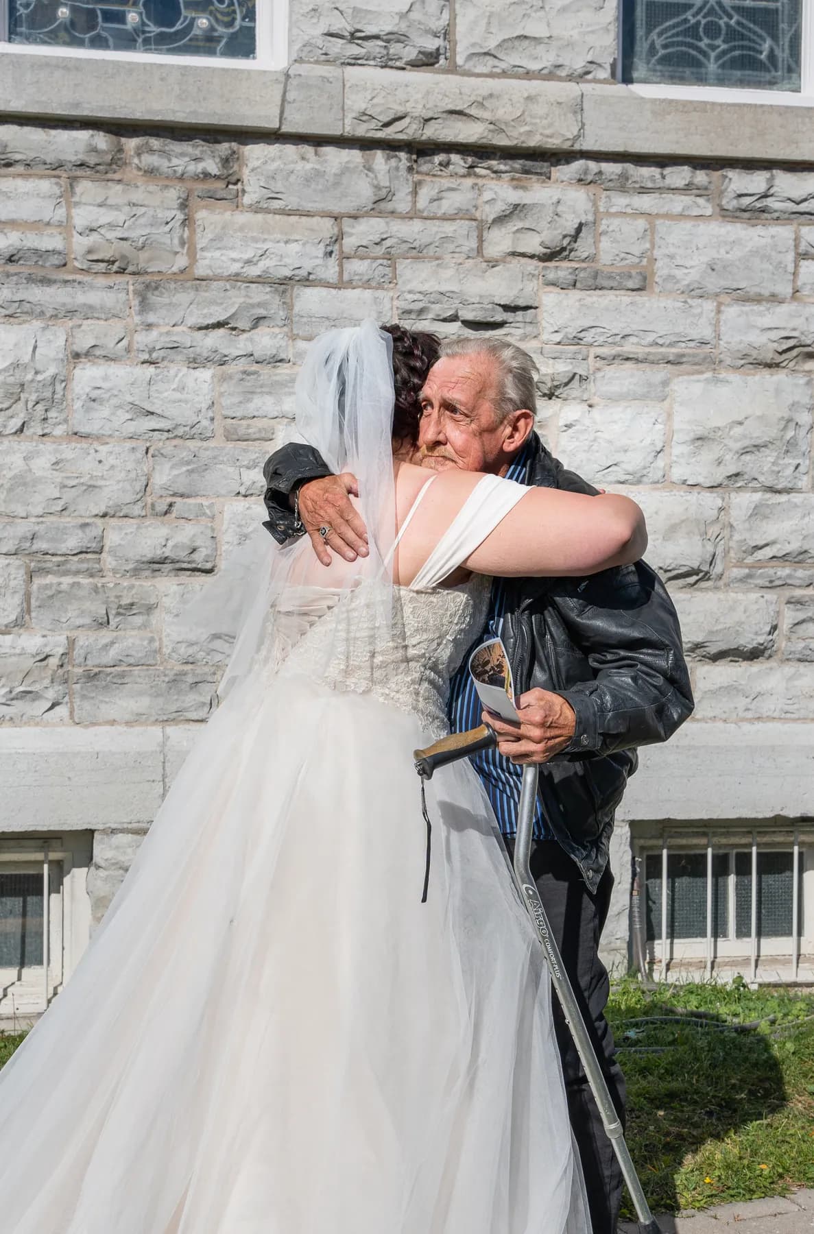 The bride posing with a male guest outside the church at Kody and Jaz’s wedding.