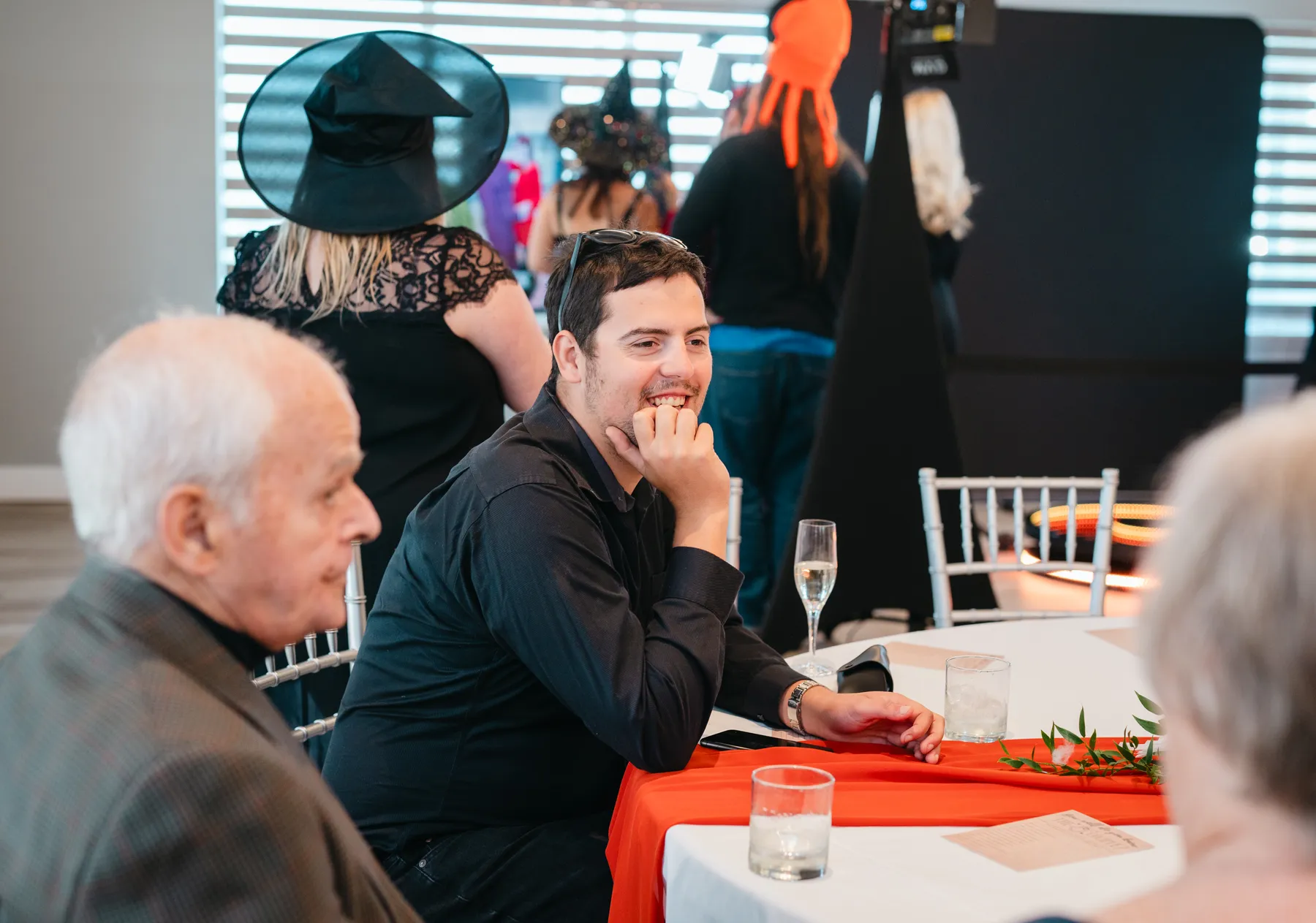 Guests seated and chatting indoors at Jenna and Jake’s Halloween party.