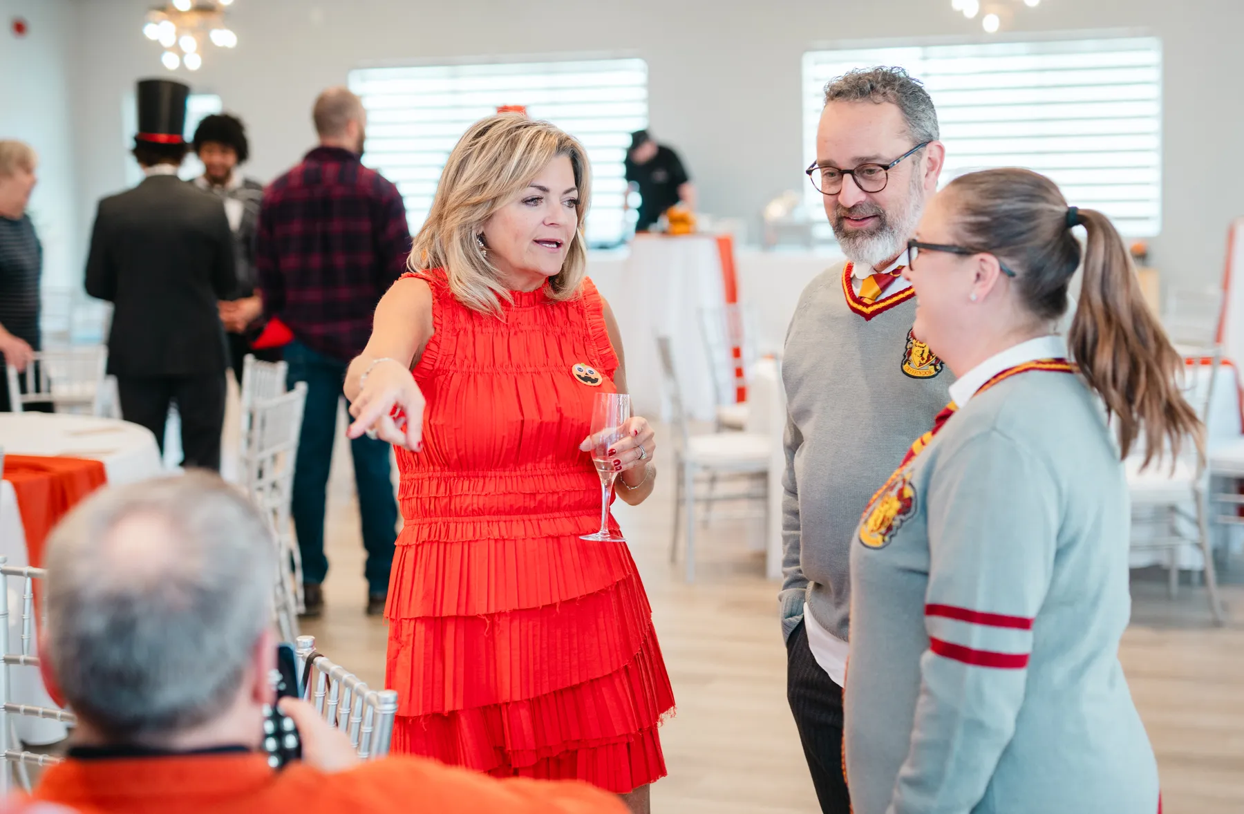Costumed guests mingling and posing indoors at Jenna and Jake’s Halloween party.