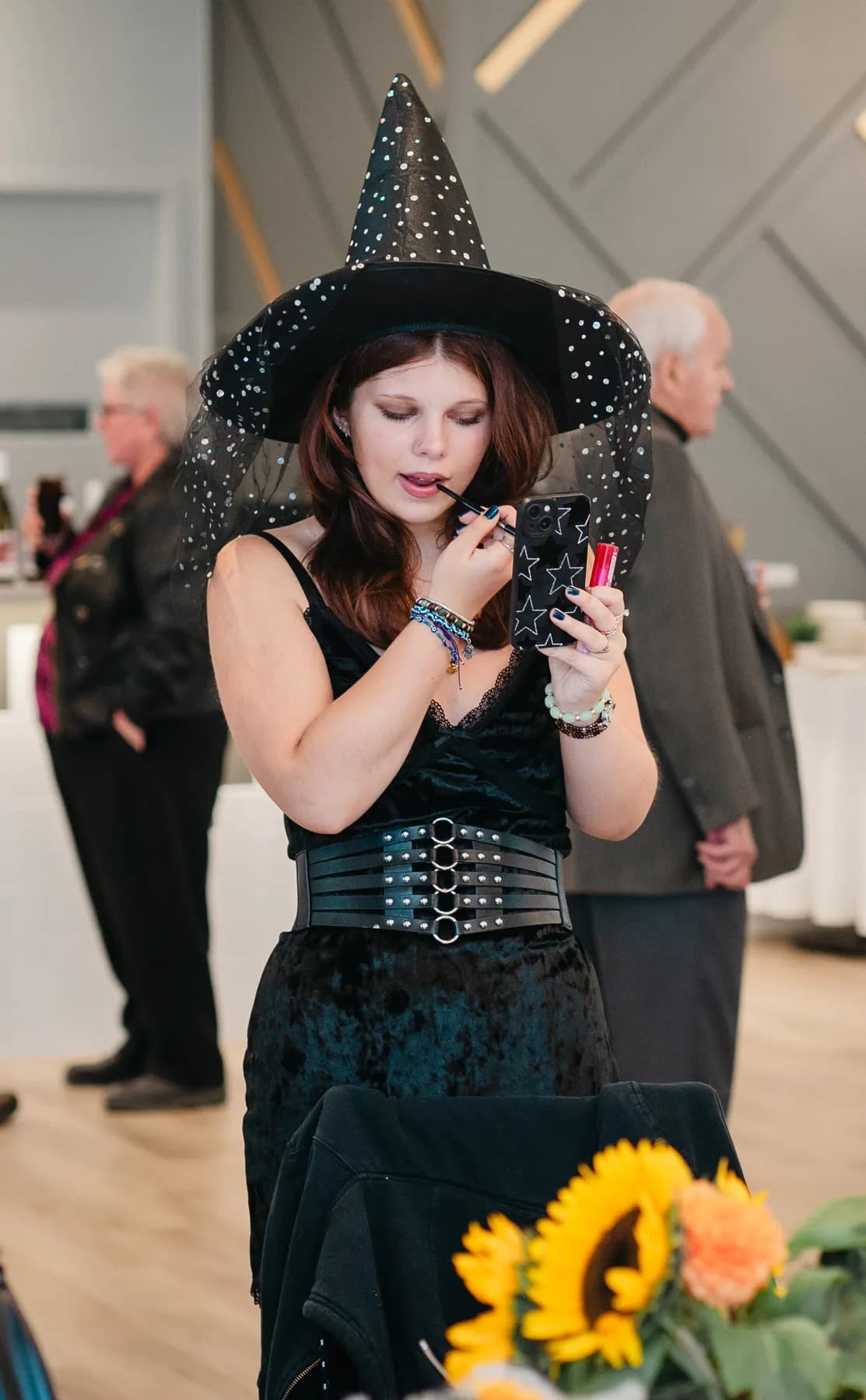 Costumed guests mingling and posing indoors at Jenna and Jake’s Halloween party.