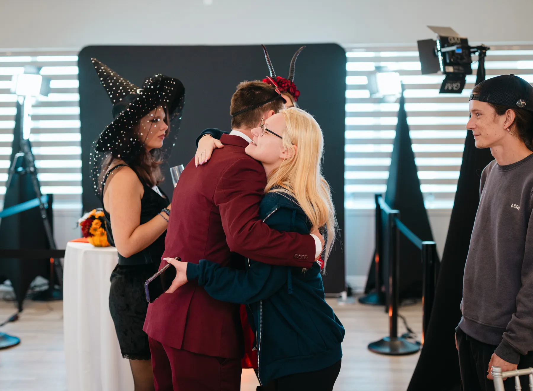 Costumed guests mingling and posing indoors at Jenna and Jake’s Halloween party.
