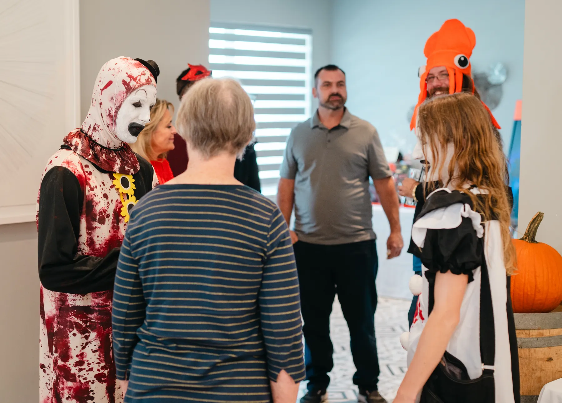 Guests in Halloween costumes talking together at Jenna and Jake’s Halloween party.