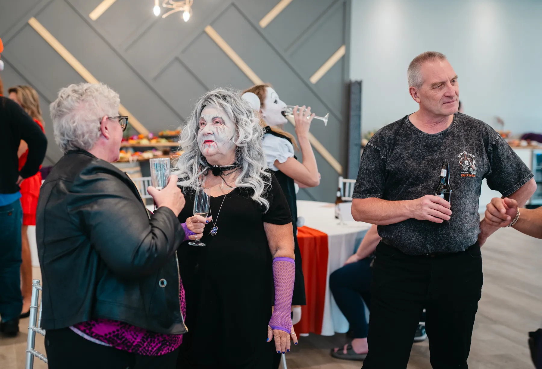 Costumed guests mingling indoors at Jenna and Jake’s Halloween party.