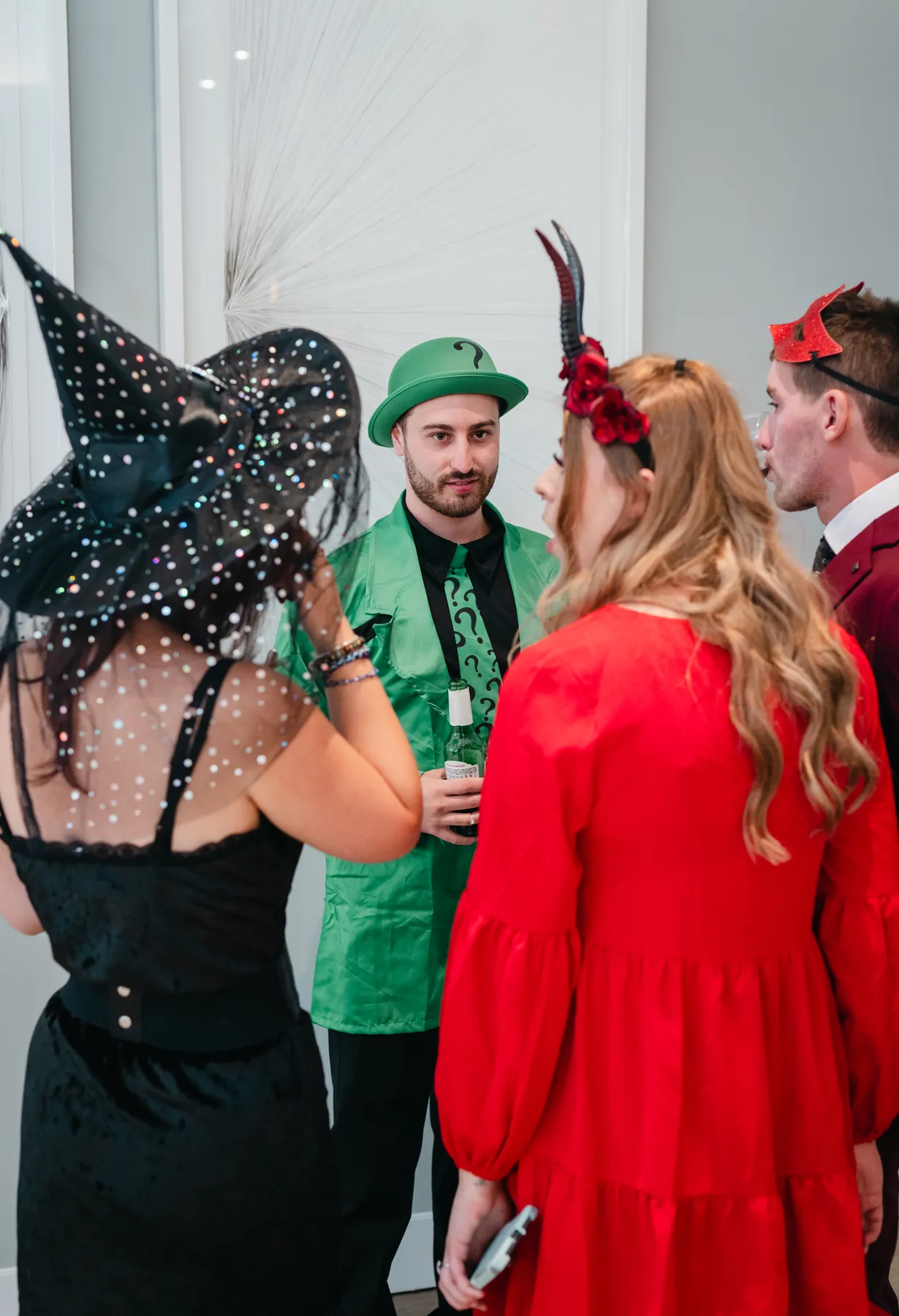Costumed guests chatting and posing at Jenna and Jake’s Halloween party.