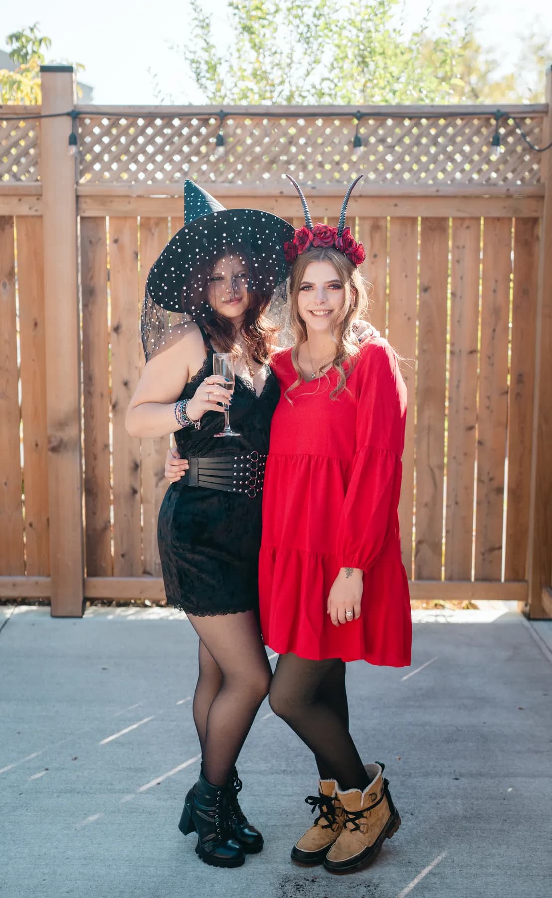 Two women celebrating together in an outdoor courtyard at Jenna and Jake’s Halloween party.