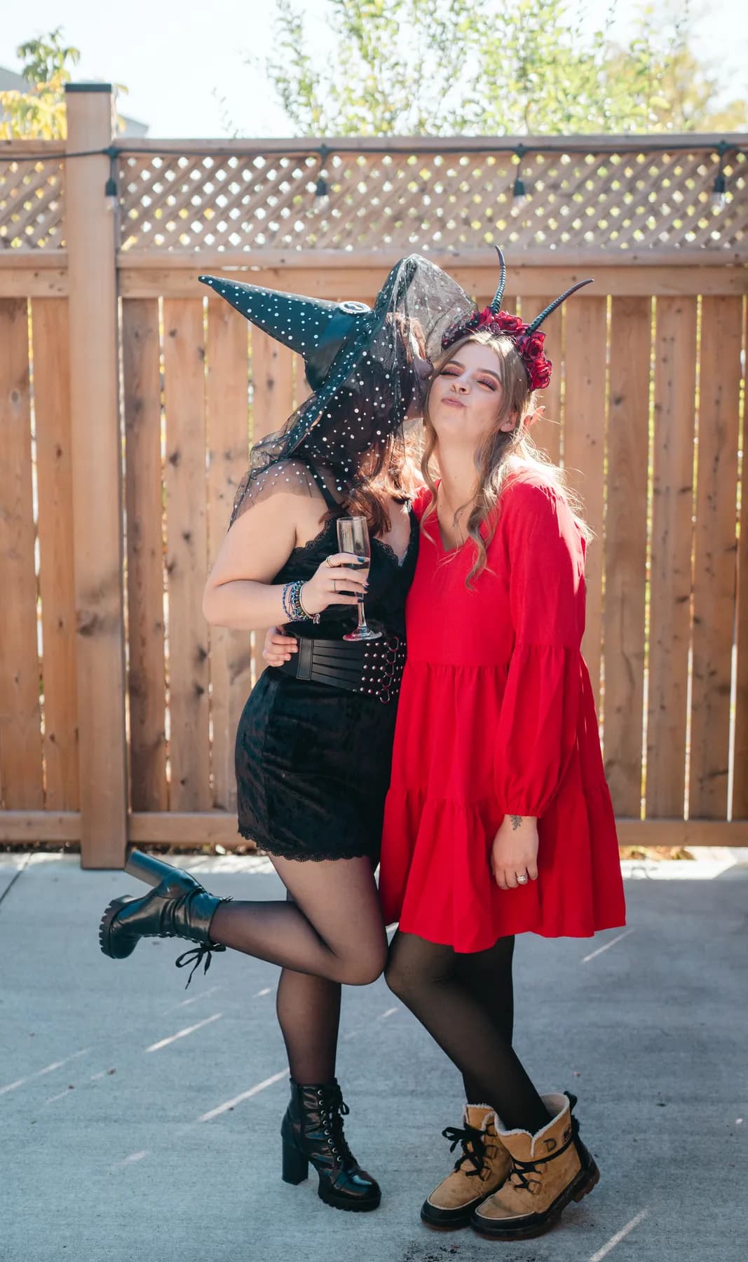 Two women celebrating together in an outdoor courtyard at Jenna and Jake’s Halloween party.