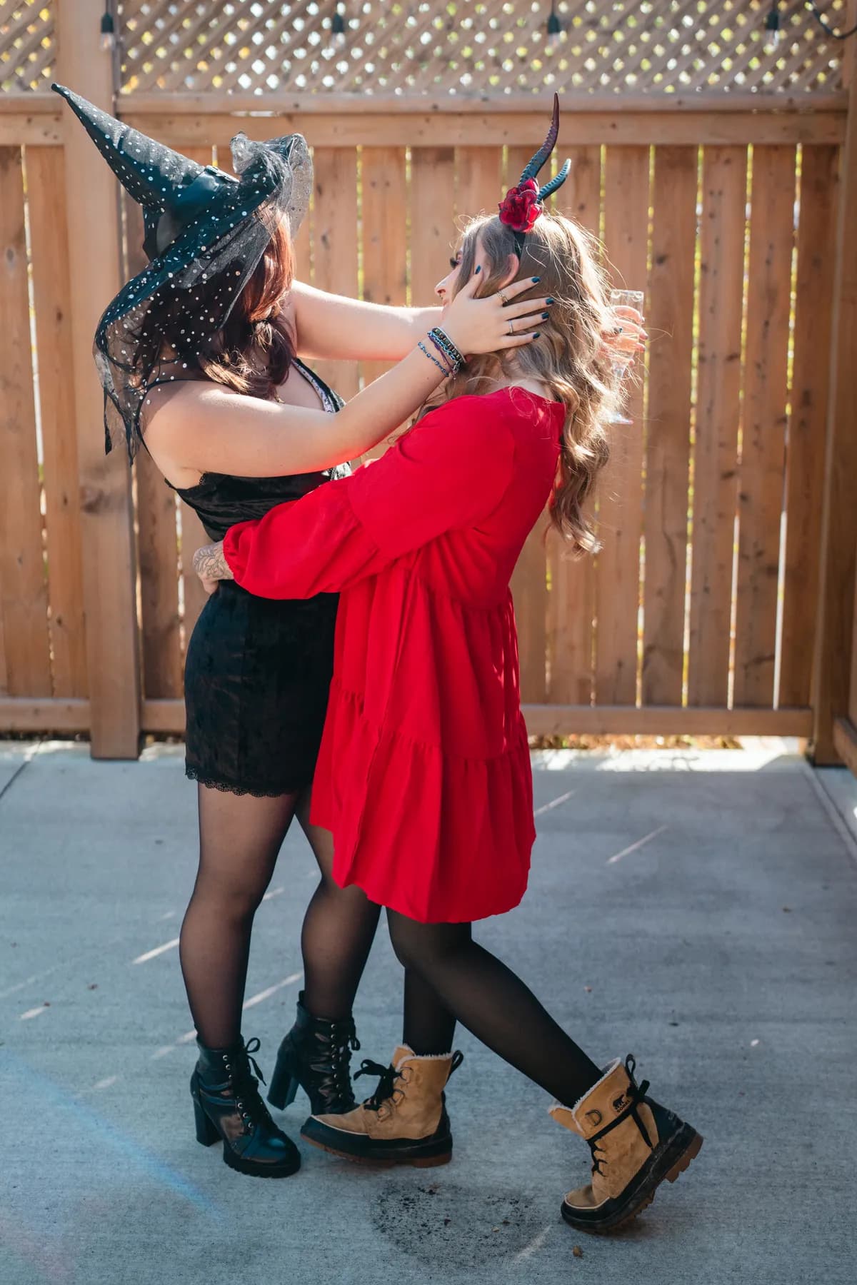 Two women celebrating together in an outdoor courtyard at Jenna and Jake’s Halloween party.