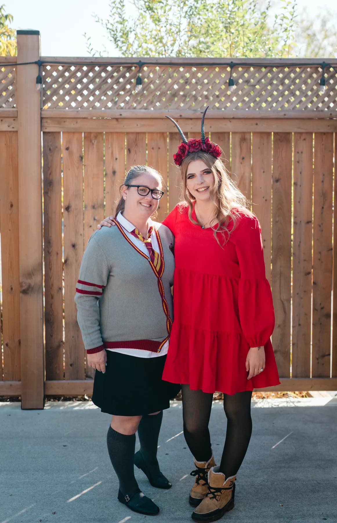Two women celebrating together in an outdoor courtyard at Jenna and Jake’s Halloween party.