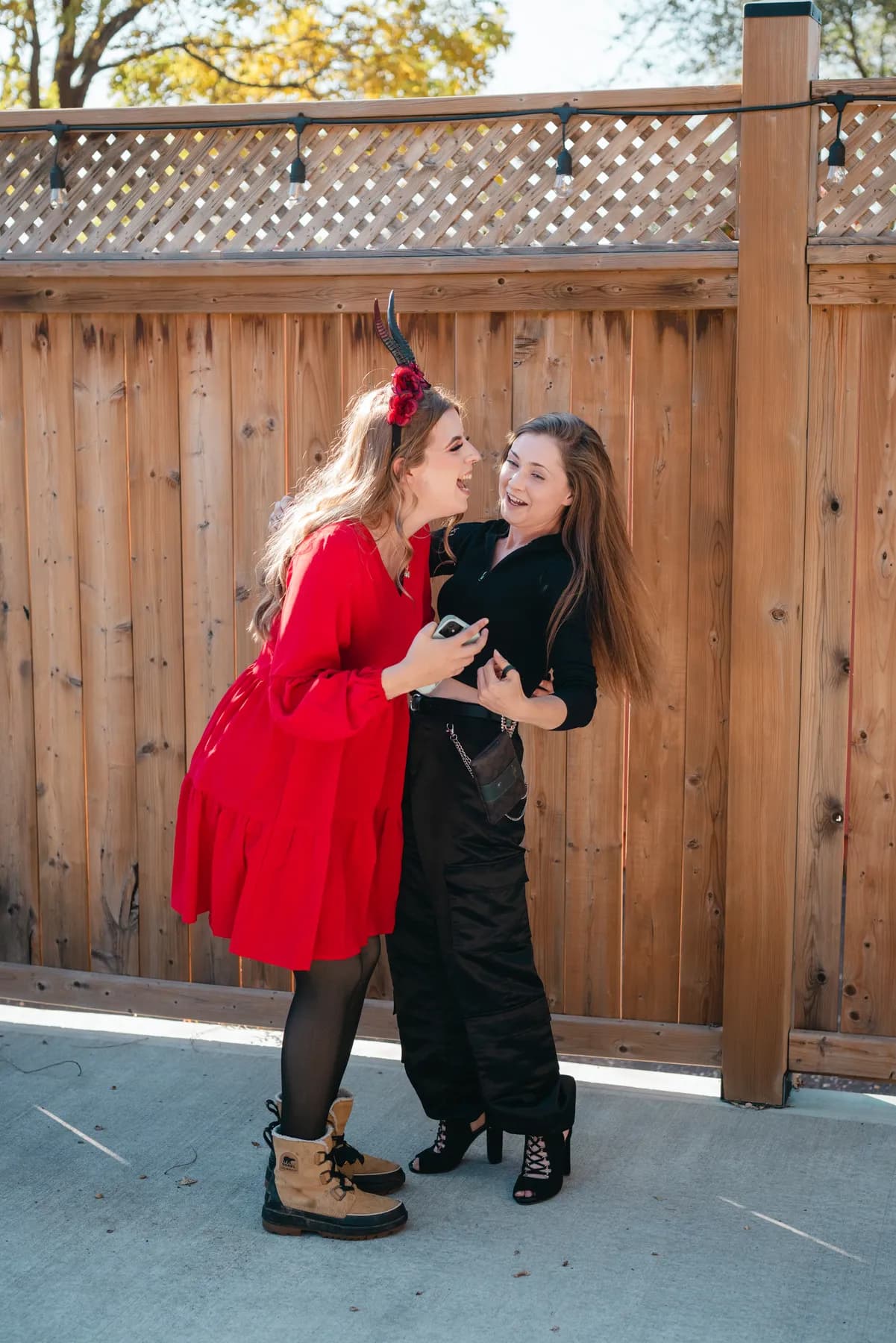 Two women dancing and posing in the outdoor courtyard at Jenna and Jake’s Halloween party.