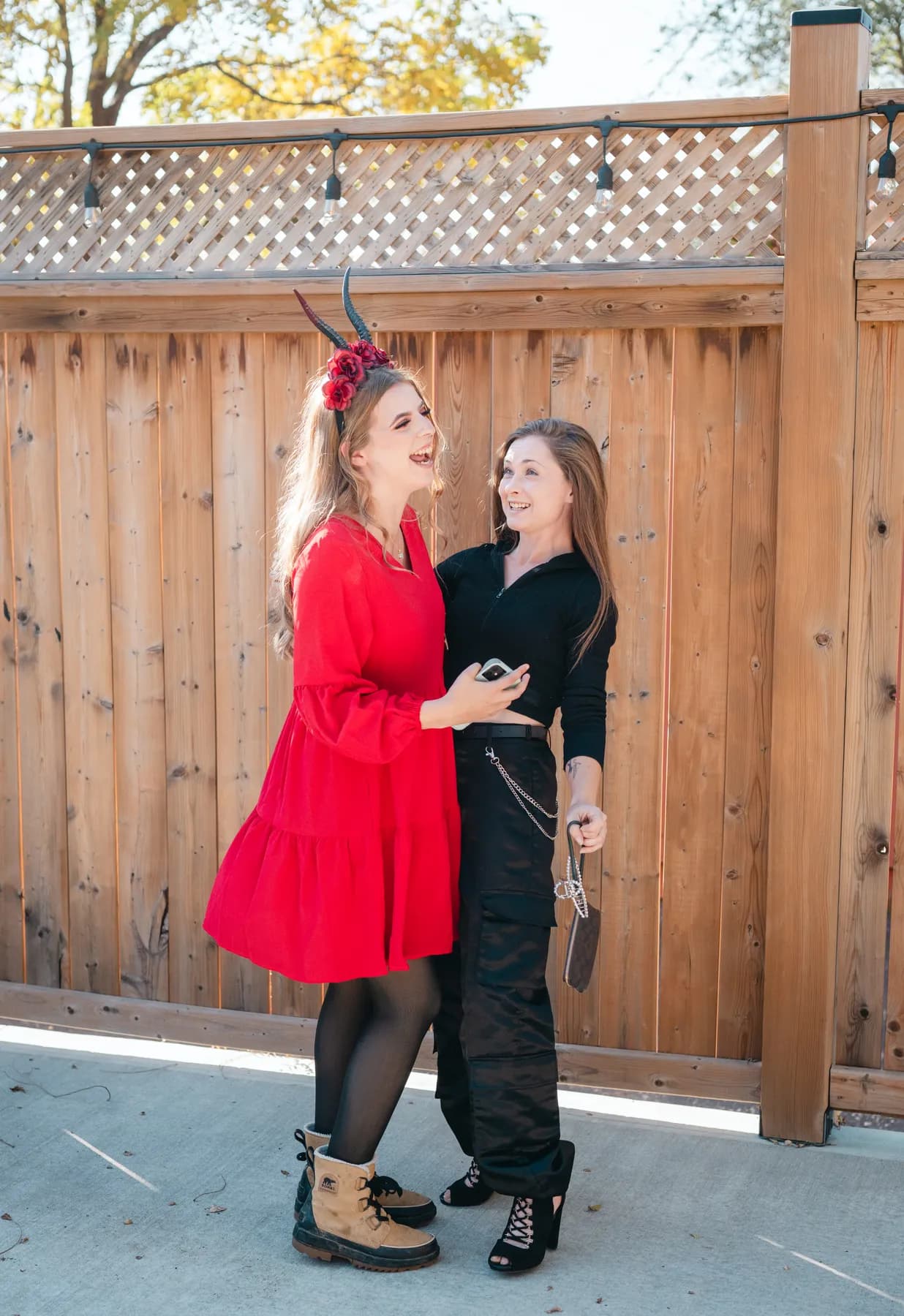 Two women dancing and posing in the outdoor courtyard at Jenna and Jake’s Halloween party.