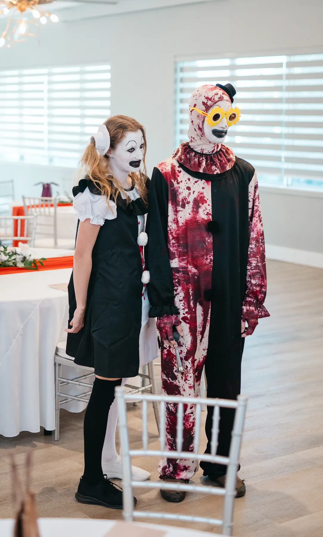 Costumed guests posing and socializing indoors at Jenna and Jake’s Halloween party.