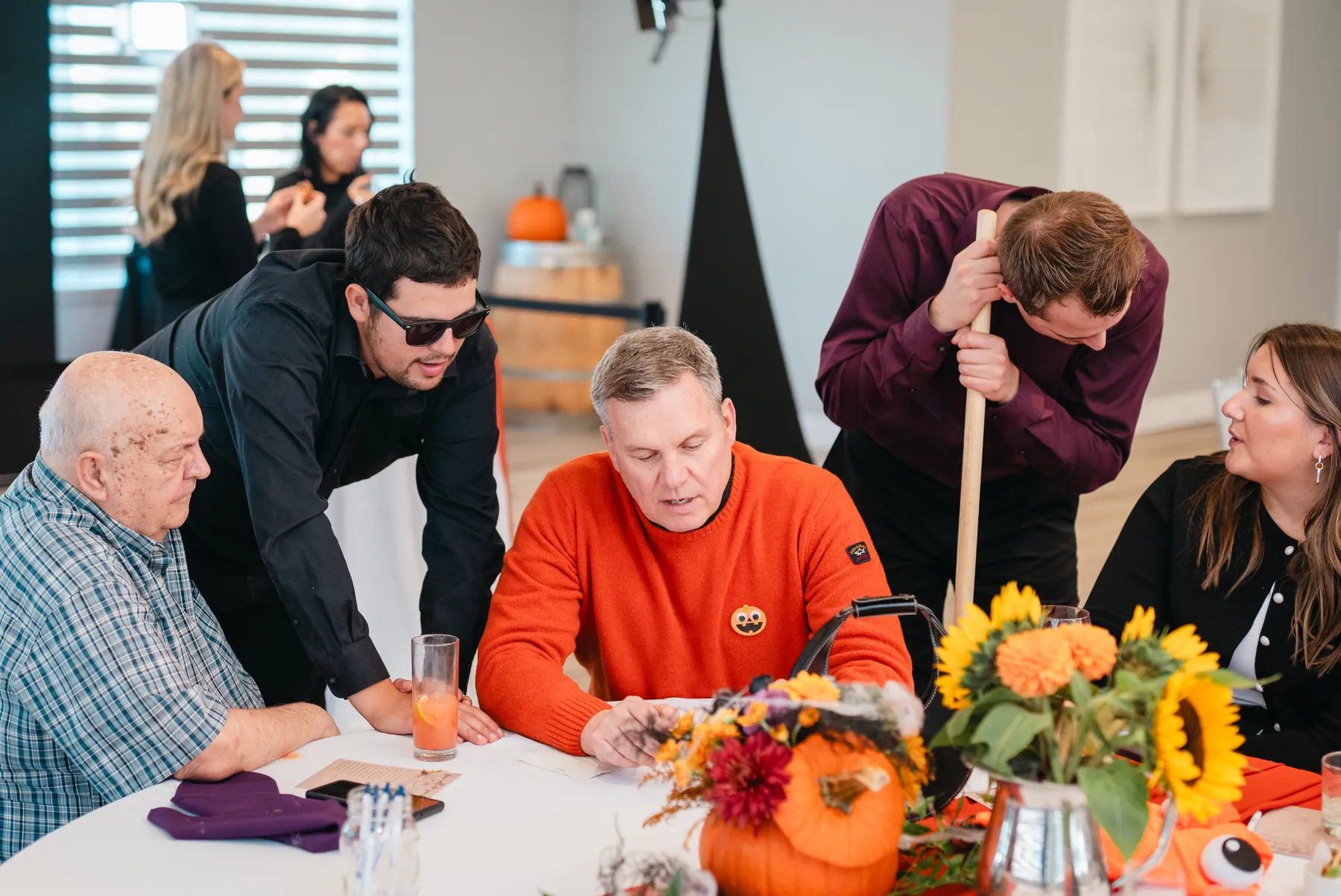 Guests seated and chatting at decorated tables at Jenna and Jake’s Halloween party.