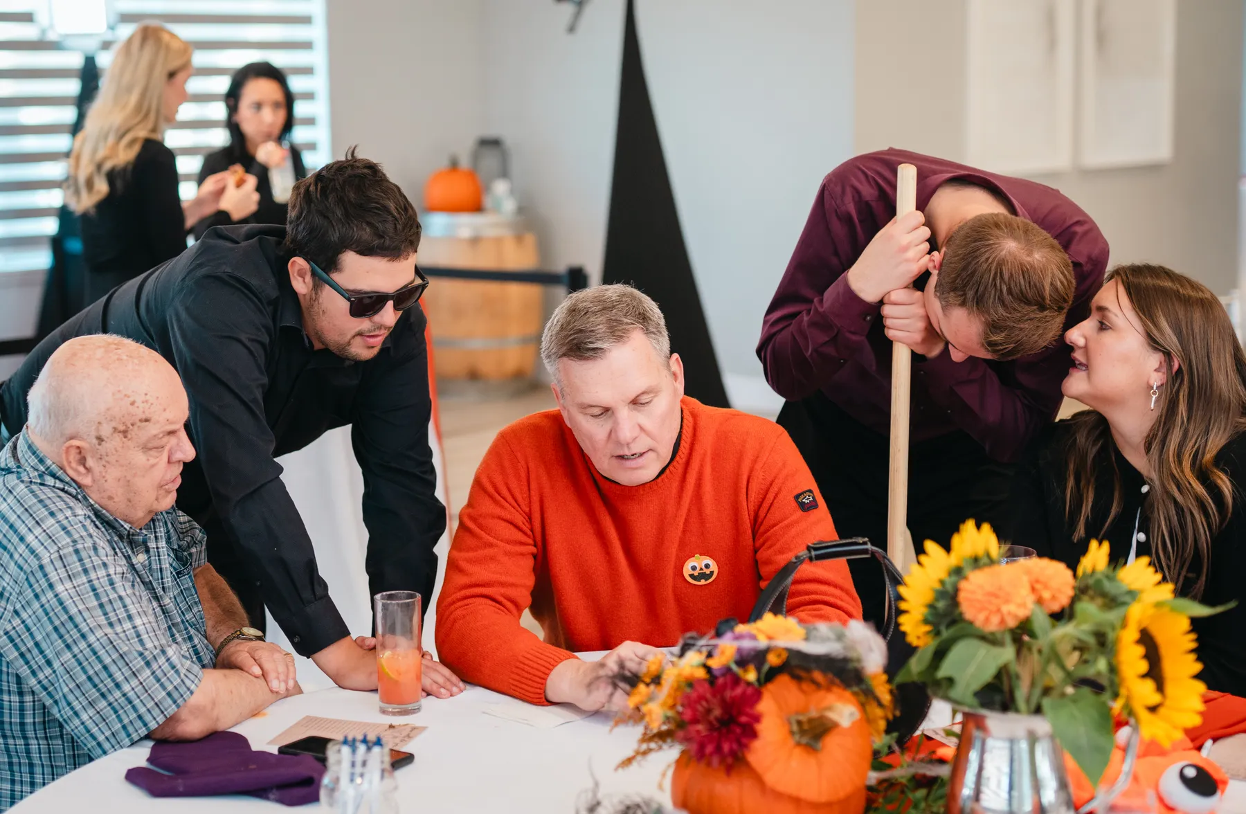 Guests seated and chatting at decorated tables at Jenna and Jake’s Halloween party.