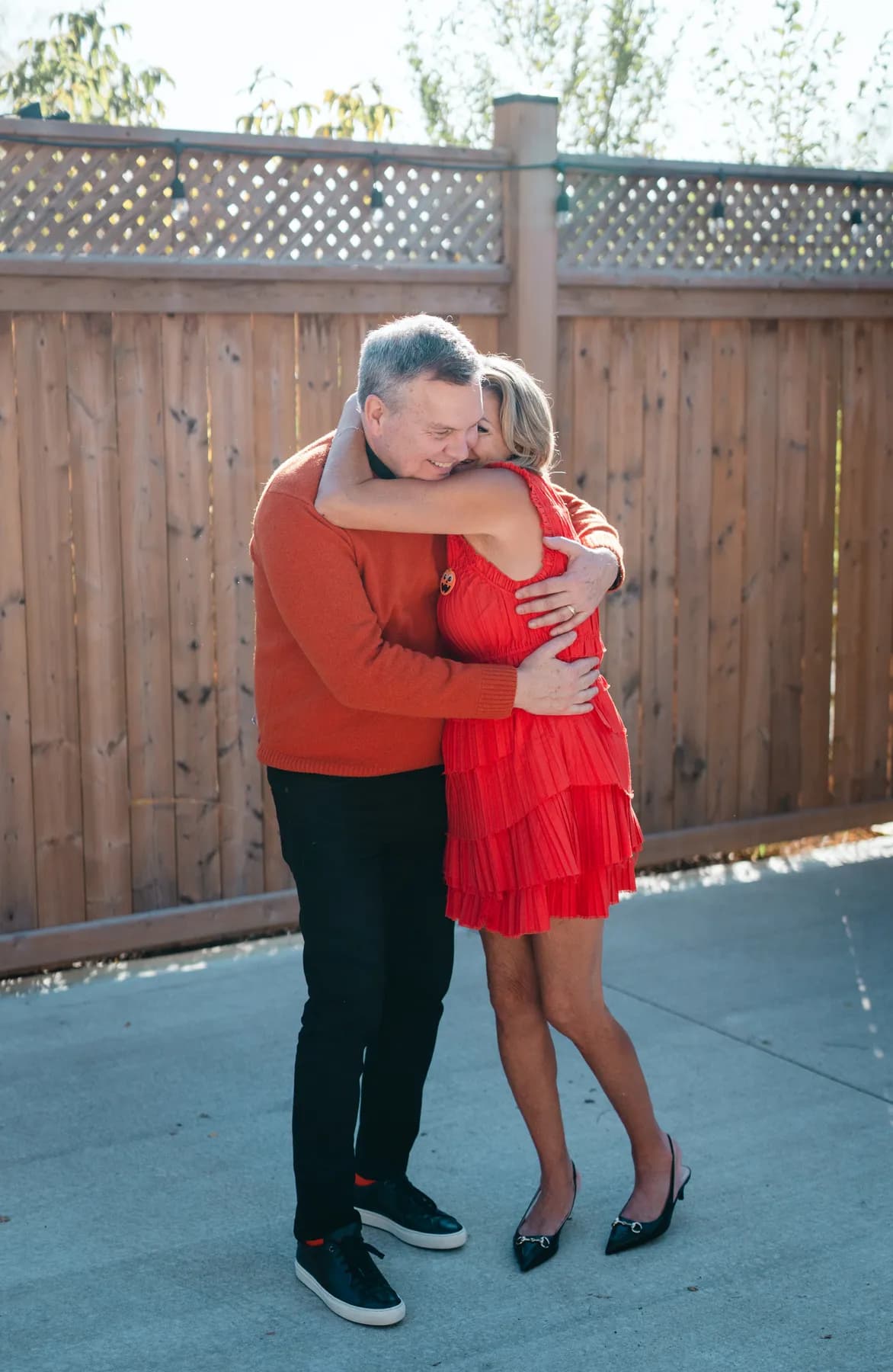 A couple posing and embracing in the outdoor courtyard at Jenna and Jake’s Halloween party.