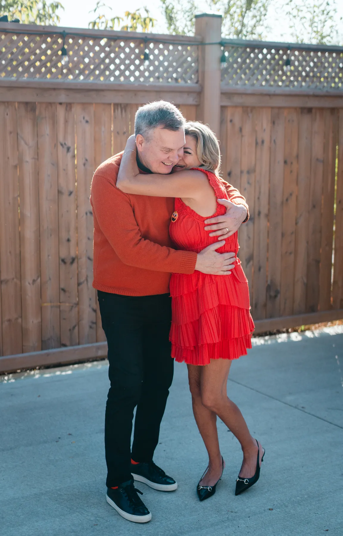 A couple posing and embracing in the outdoor courtyard at Jenna and Jake’s Halloween party.