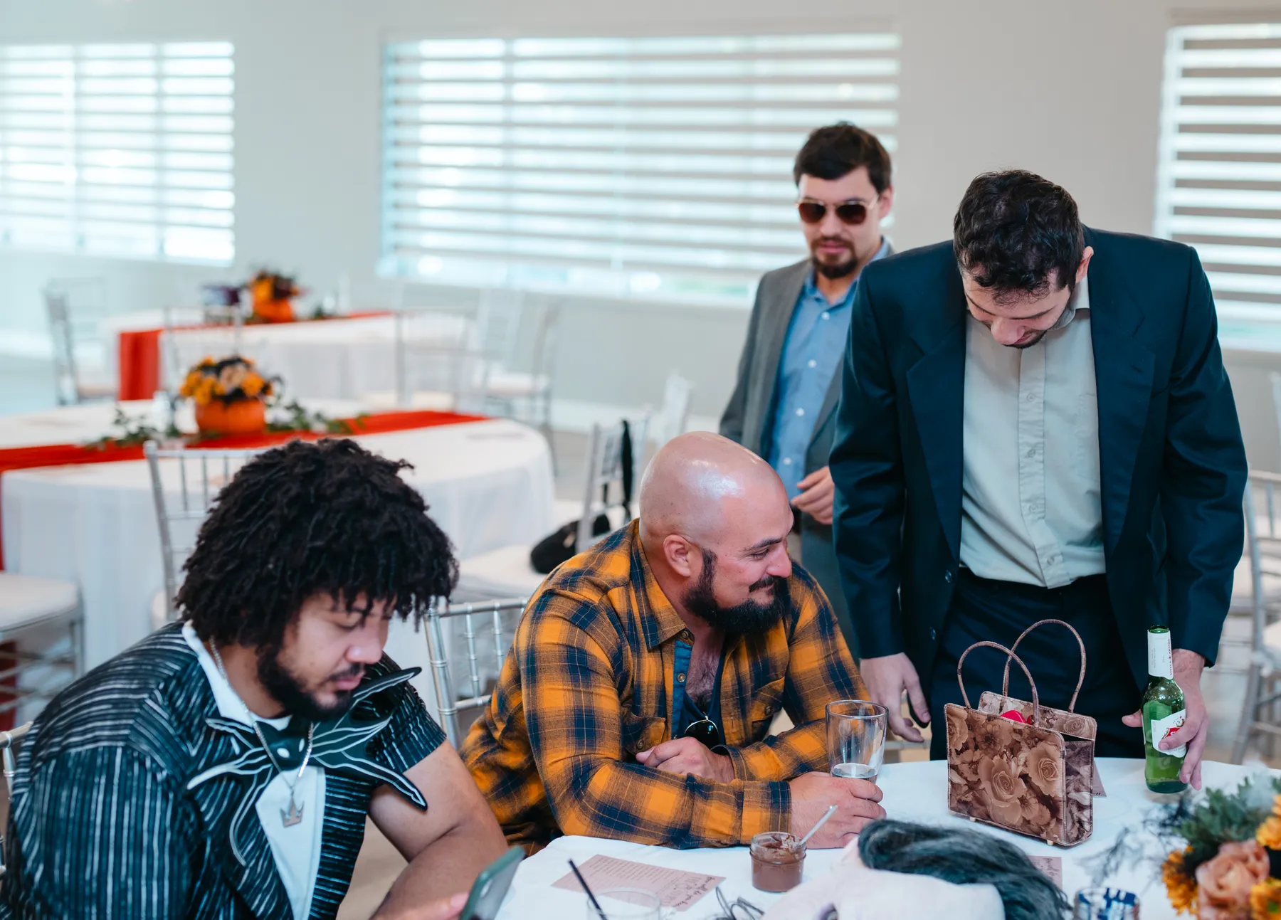 Guests mingling around a table at Jenna and Jake’s Halloween party.