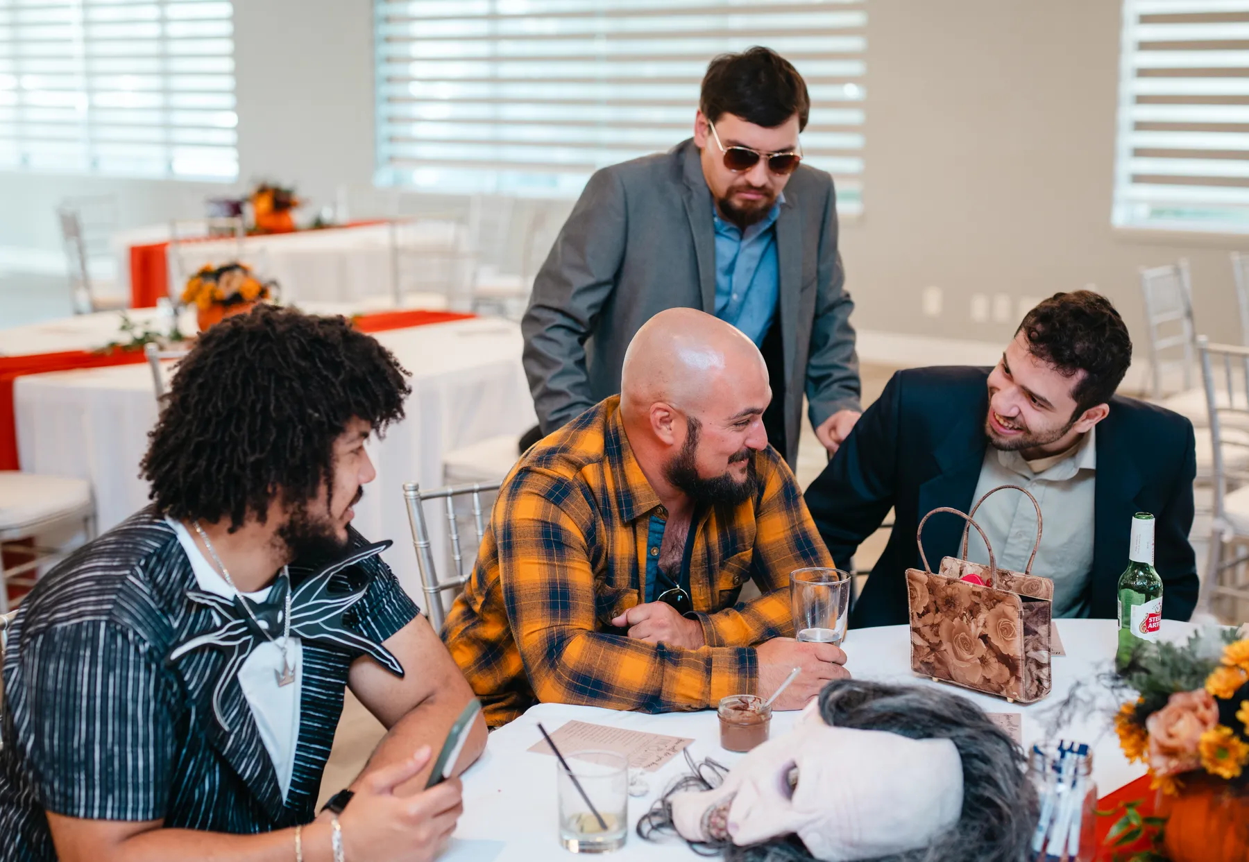 Guests mingling around a table at Jenna and Jake’s Halloween party.