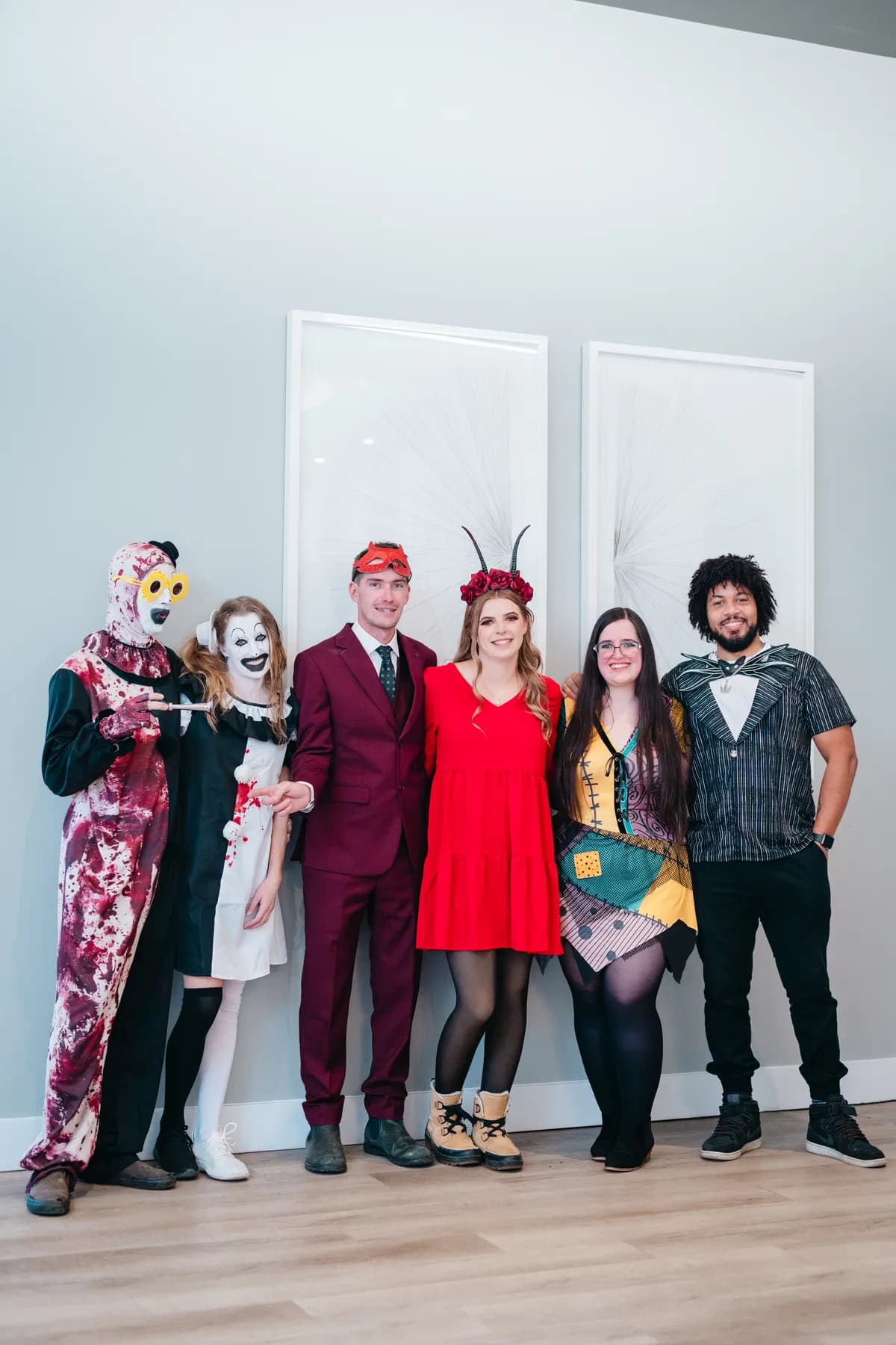 Groups of costumed guests posing indoors at Jenna and Jake’s Halloween party.