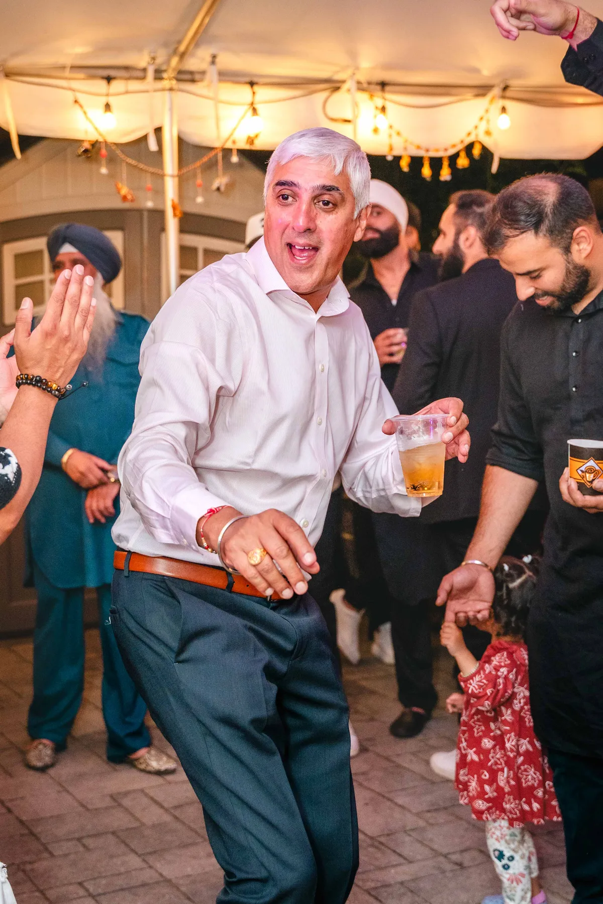 Guests dancing under evening lights at Aaron’s Haldi celebration.