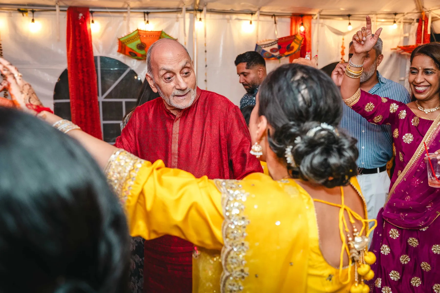 Guests dancing under evening lights at Aaron’s Haldi celebration.