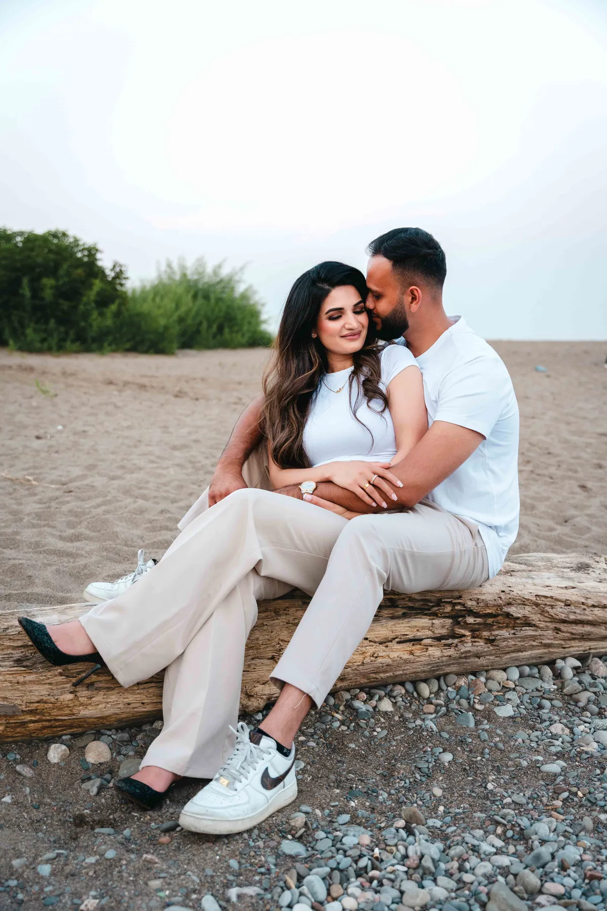 The couple seated together on the beach at A and F’s couples session.