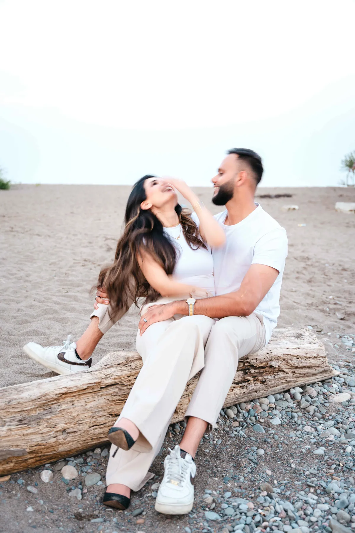 The couple seated together on the beach at A and F’s couples session.
