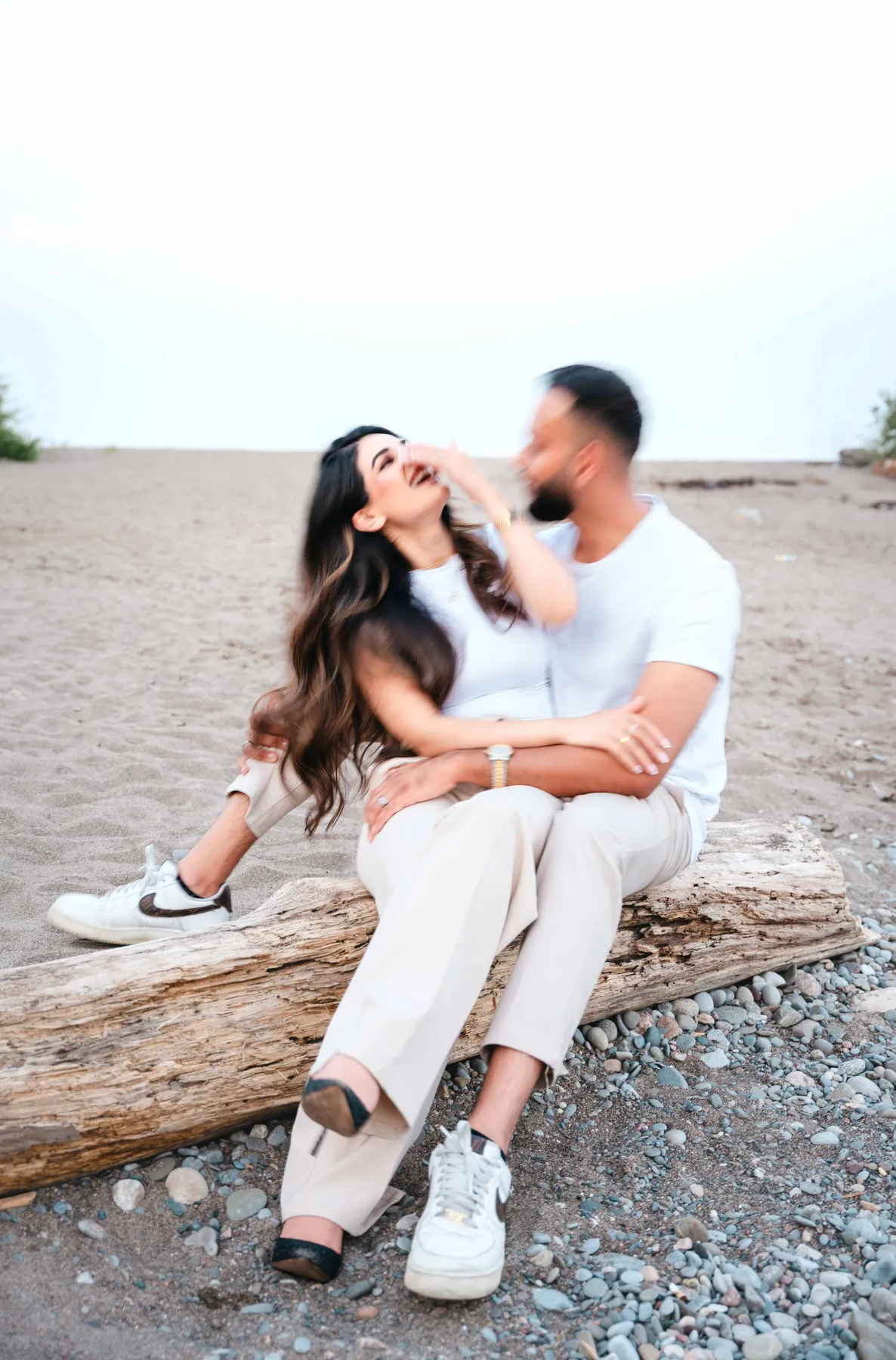 The couple seated together on the beach at A and F’s couples session.