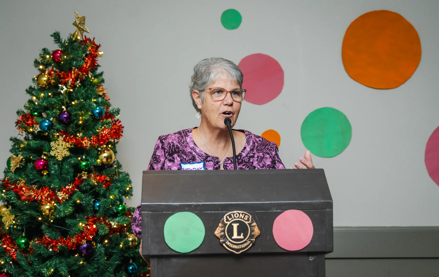 A woman speaking at the lectern at Alison’s birthday celebration.