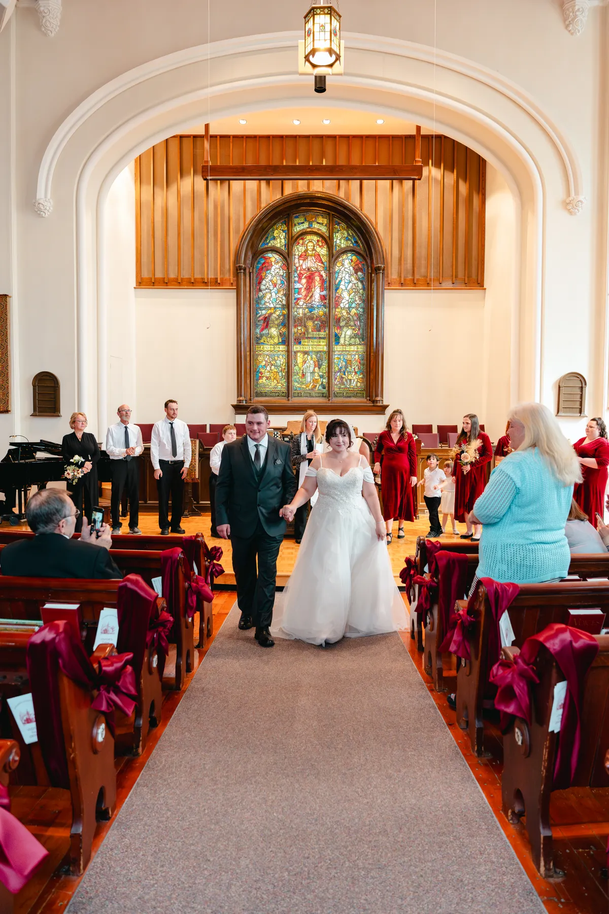 The couple walking down the church aisle after the ceremony at Kody and Jaz’s wedding.