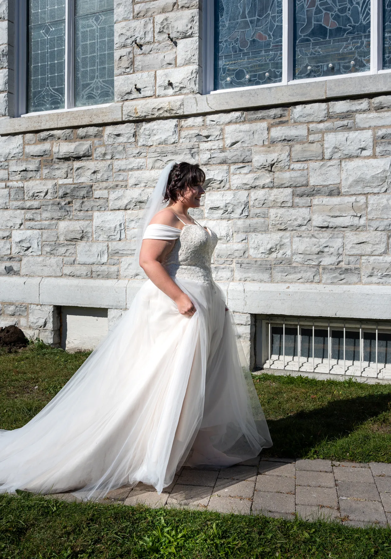 The bride posing with a male guest outside the church at Kody and Jaz’s wedding.